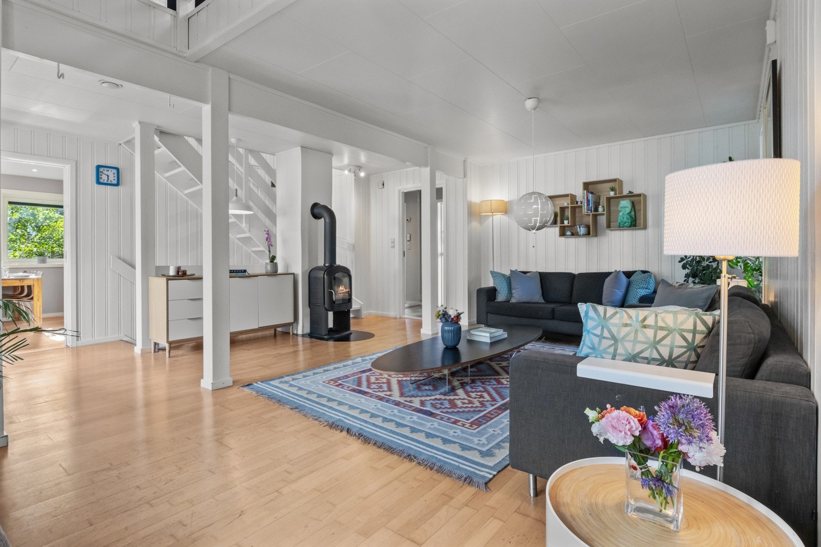 Langs veggen inn mot kjøkkenet er det en hvitmalt trapp med åpne trinn som binder etasjene sammen Galleribilde