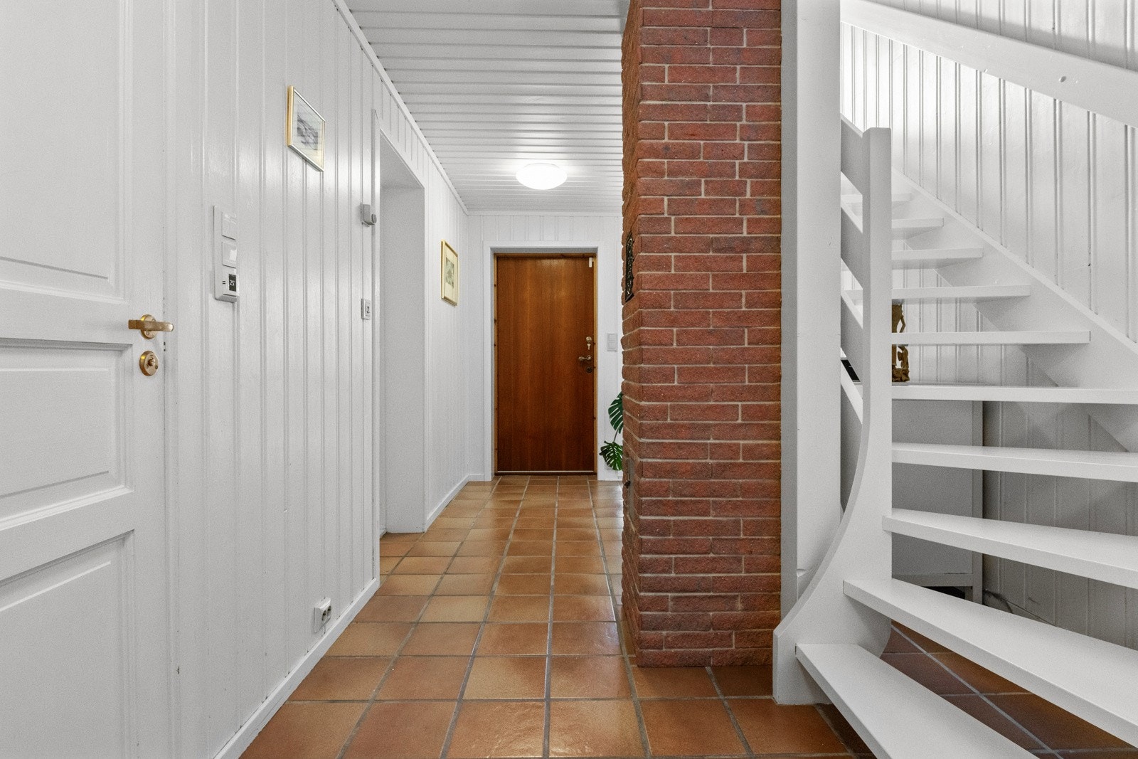 Gangen i underetasje har panelkledde vegger og flislagt gulv med gulvvarme Galleribilde