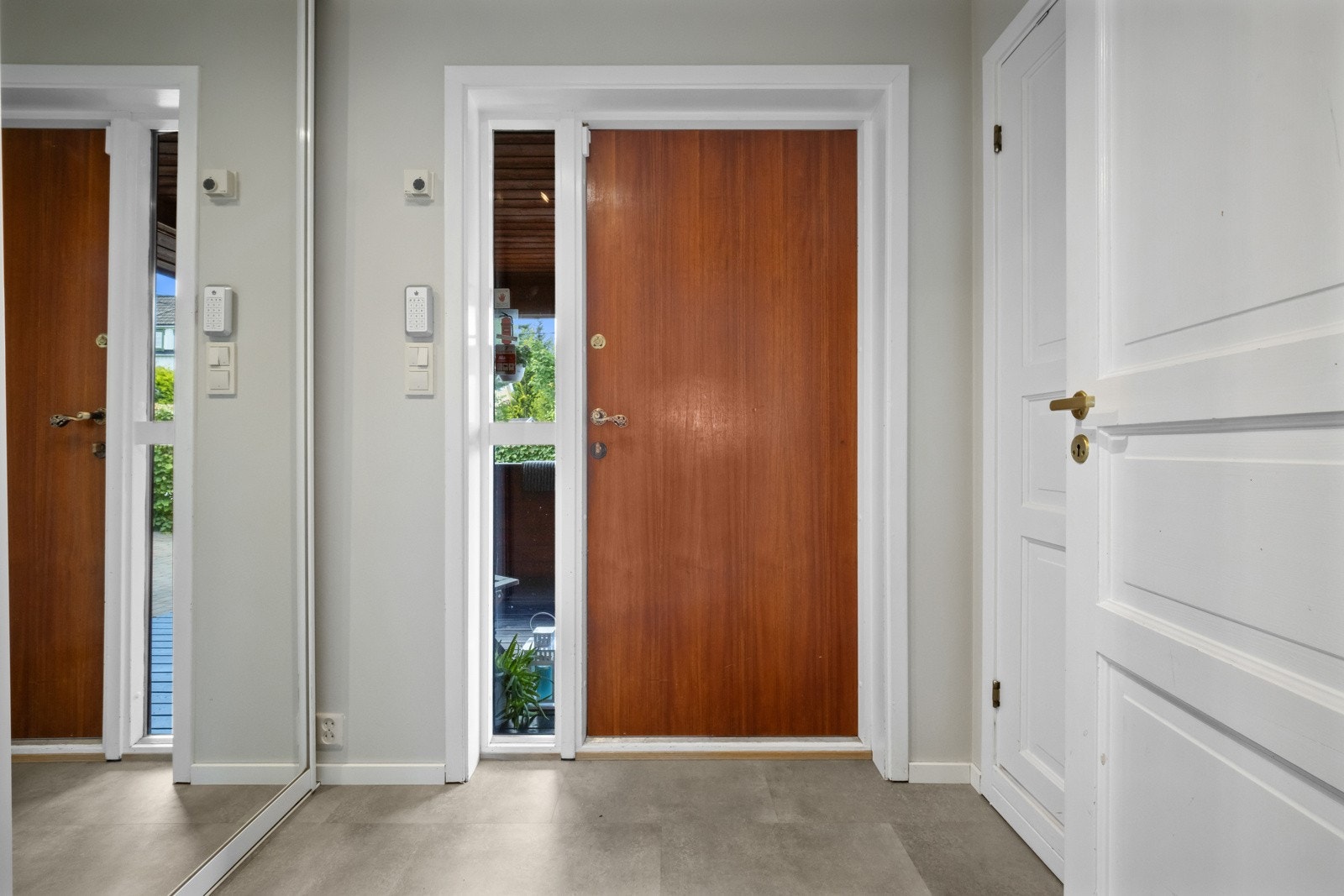 Entreen ligger i første etasje, og er pent innredet med slette, malte veggflater og flismønstret belegg på gulvet med gulvvarme Galleribilde