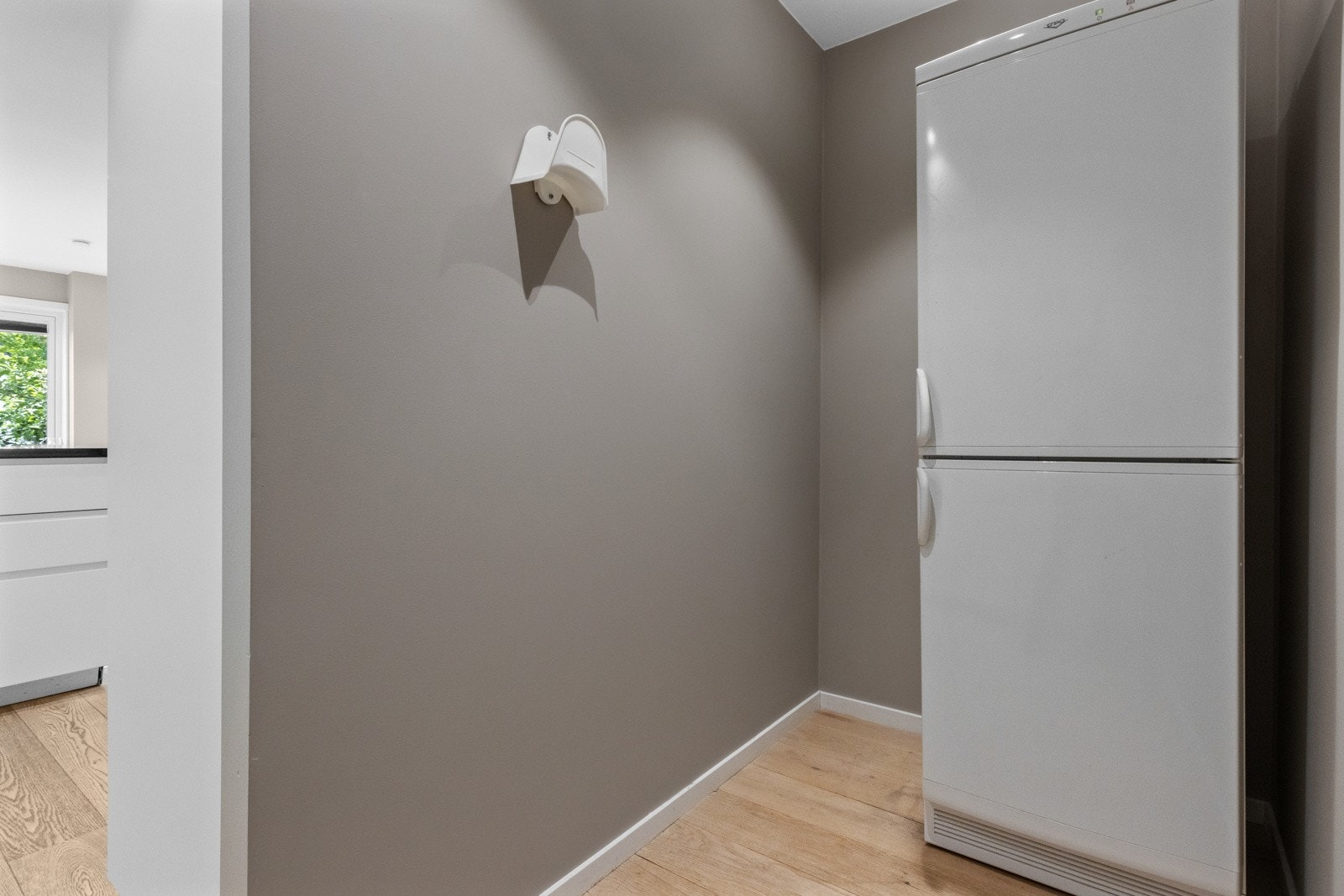 Bakenfor deler av kjøkkeninnredningen er det en skjermet del, perfekt til støvsugerslanger, ekstra kjøleskap, fryser og annet Galleribilde