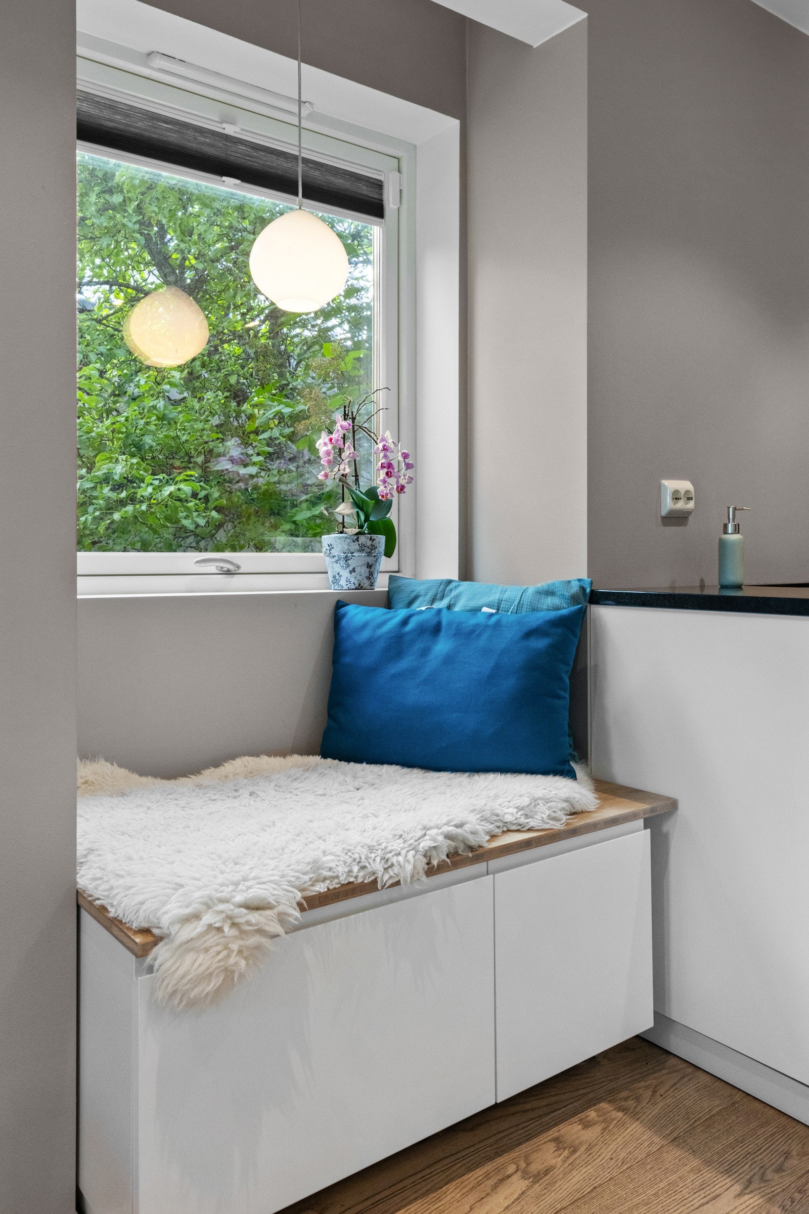 Under det ene vinduet er det en koselig sittebenk med skuffer til oppbevaring Galleribilde