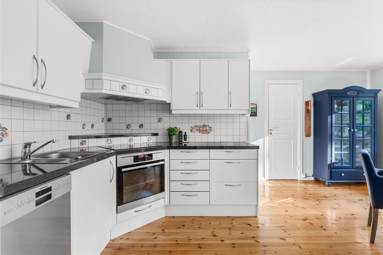 Videre er det integrert komfyr og platetopp, samt plass til frittstående kjøleskap. Over platetoppen er det tilkoblet en kjøkkenventilator. Galleribilde