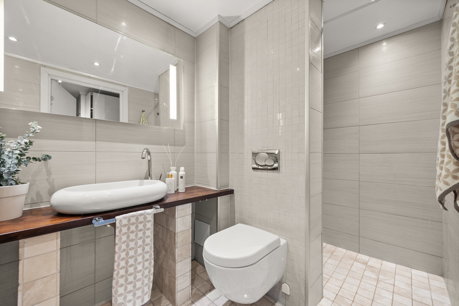 Det er gulvvarme, og opplegg for vaskemaskin og tørketrommel under benkeplate Galleribilde