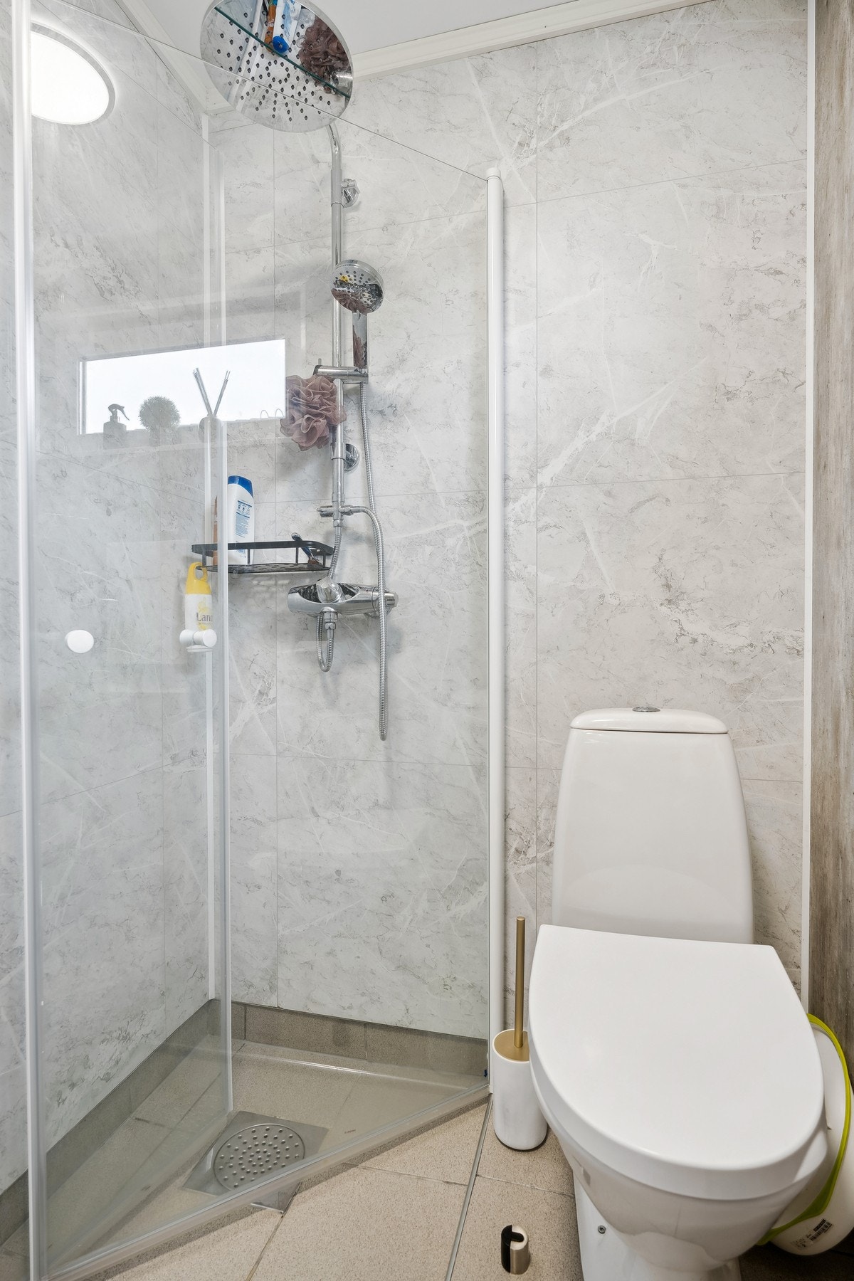 Badet er utstyrt med baderomsinnredning, dusjhjørne og toalett Galleribilde