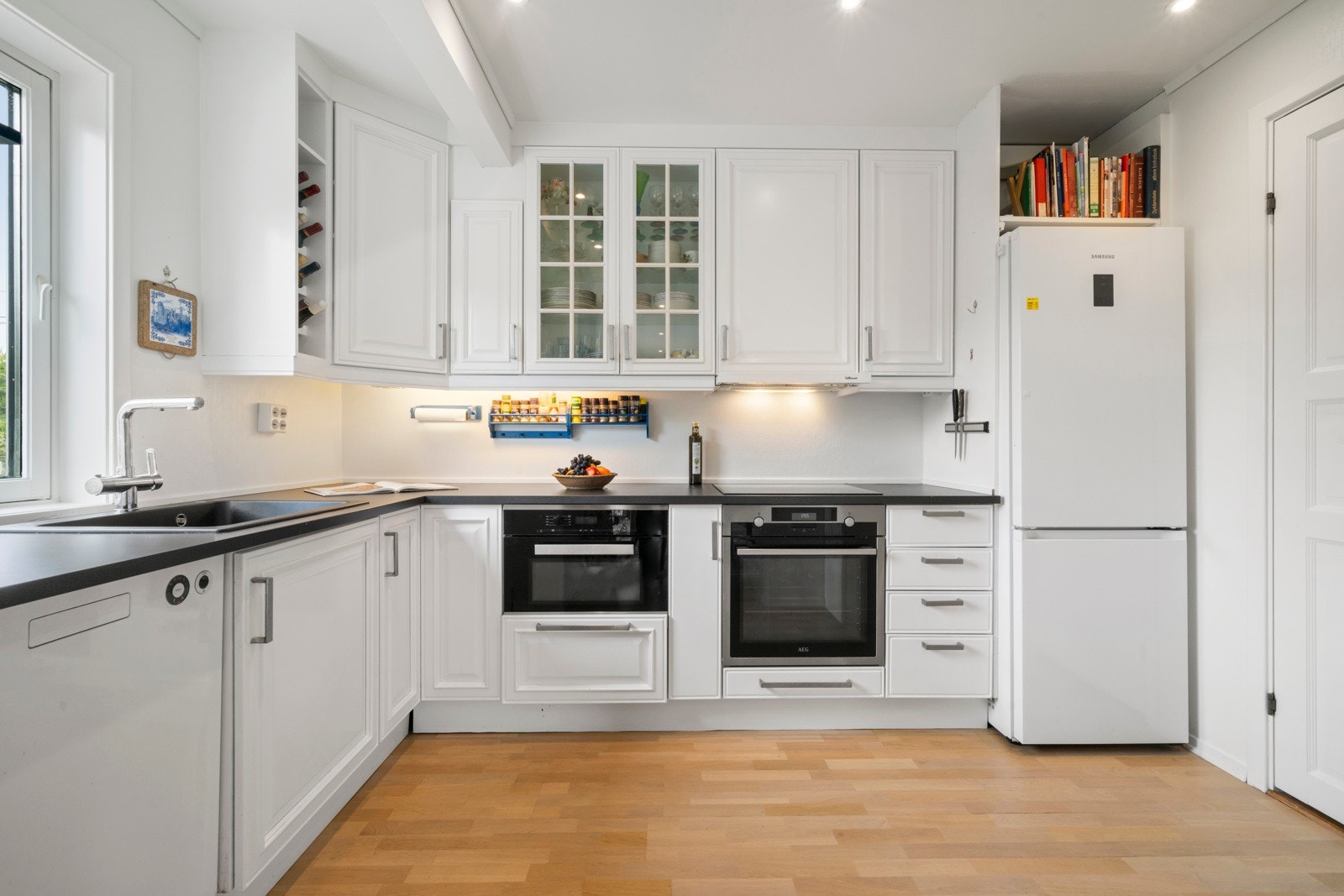 Flott kjøkkeninnredning med hvite profilerte fronter og laminert benkeplate Galleribilde