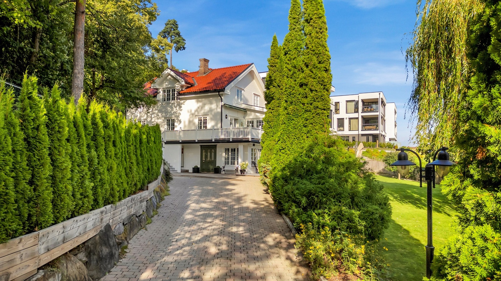 Gårdsplassen og innkjørselen er steinbelagt, og boligen ligger fint plassert på tomten. Galleribilde