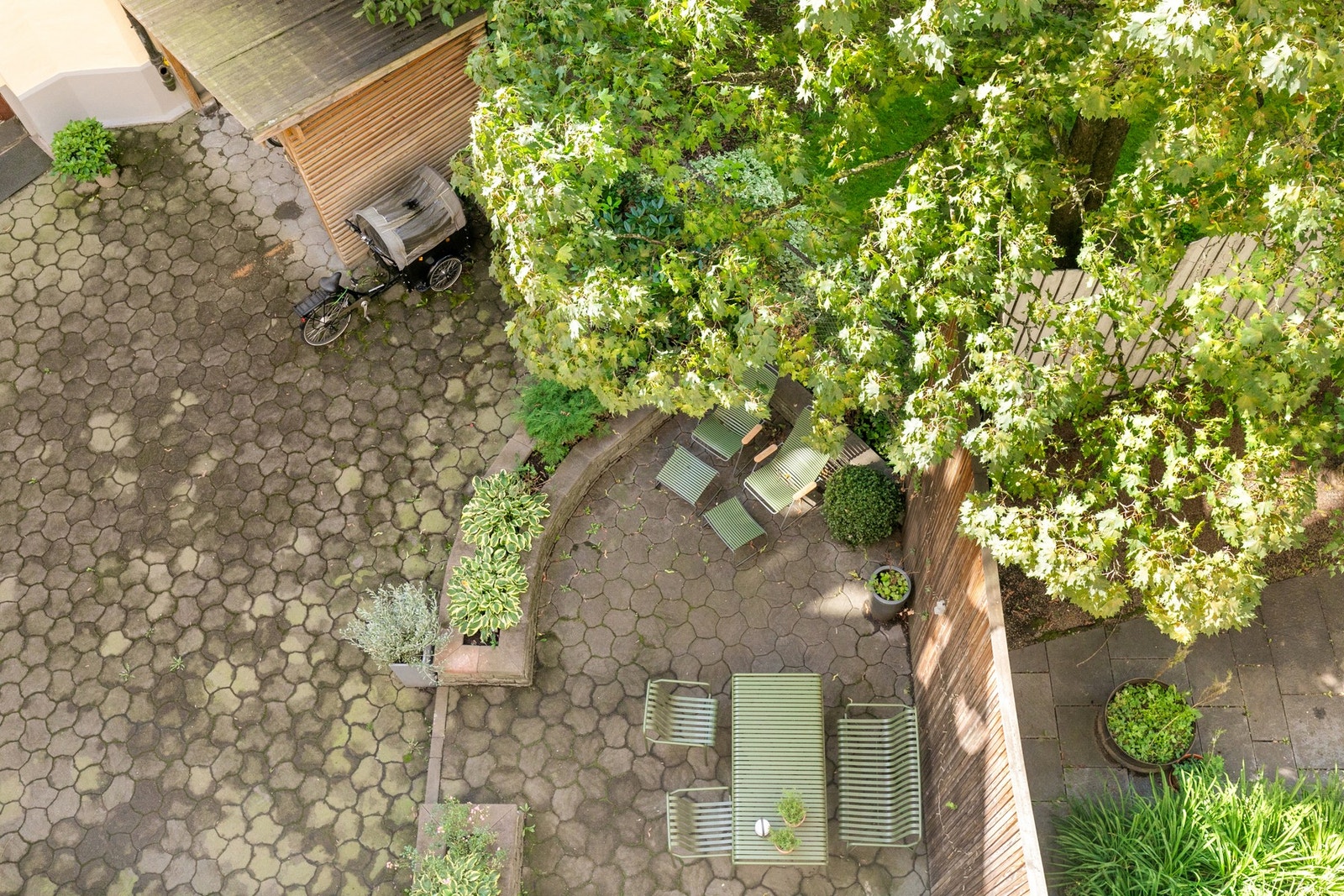 Pent opparbeidet gårdsrom med beplantning og sittegrupper. Galleribilde