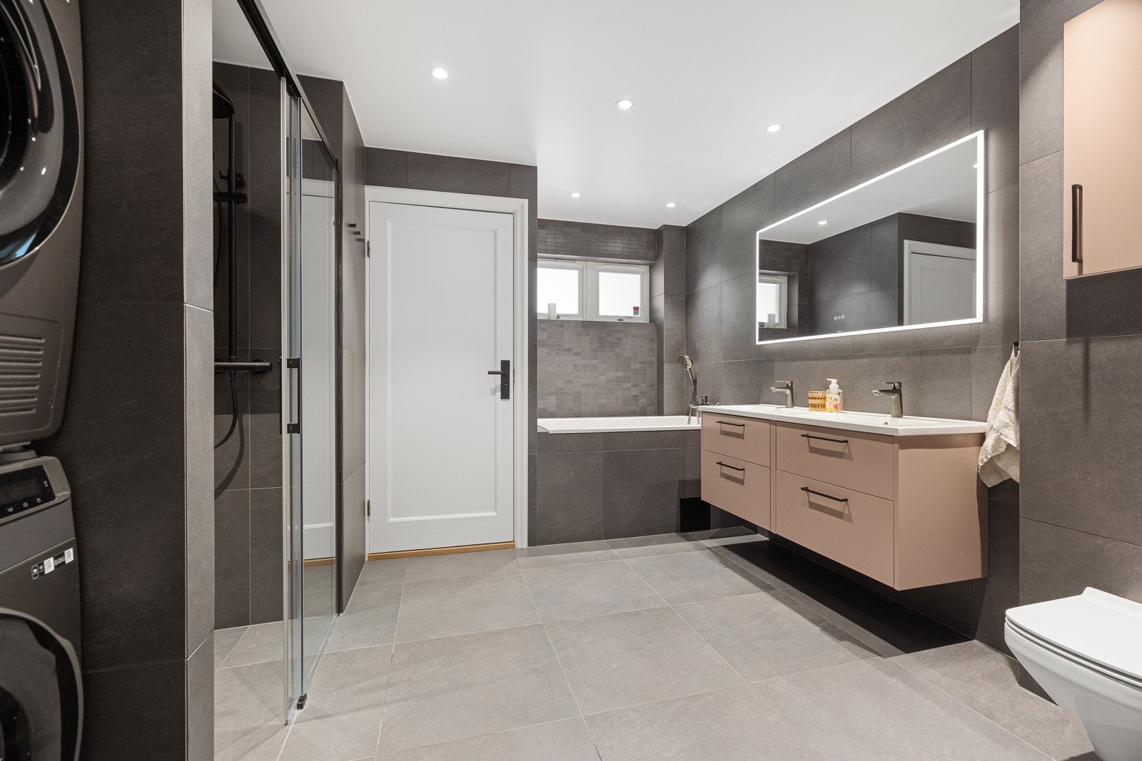 Bad (1 etasje) - Flislagt baderom (Nytt 2023), med varmekabler, avtrekk, belysning, samt opplegg for vaskemaskin og tørketrommel. Badet har innmurt badekar, dobbel servant med innredning, toalett, dusj med skyvedør i glass. Speil med dimbart lys. Galleribilde