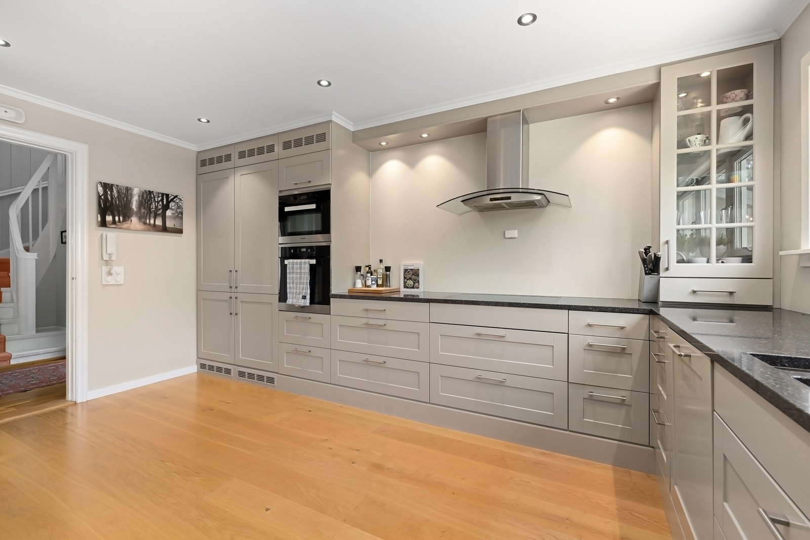 Profilert malt innredning fra Huseby. Kjøkkenet har, Miele hvitevarer, granitt benkeplate med underlimt stålkum og planlimt induksjonstopp, integrert kjøl/frys, oppvaskmaskin, komfyr og komfyr/micro, samt Quooker. Kjøkkenventilator med avtrekk ut. Galleribilde