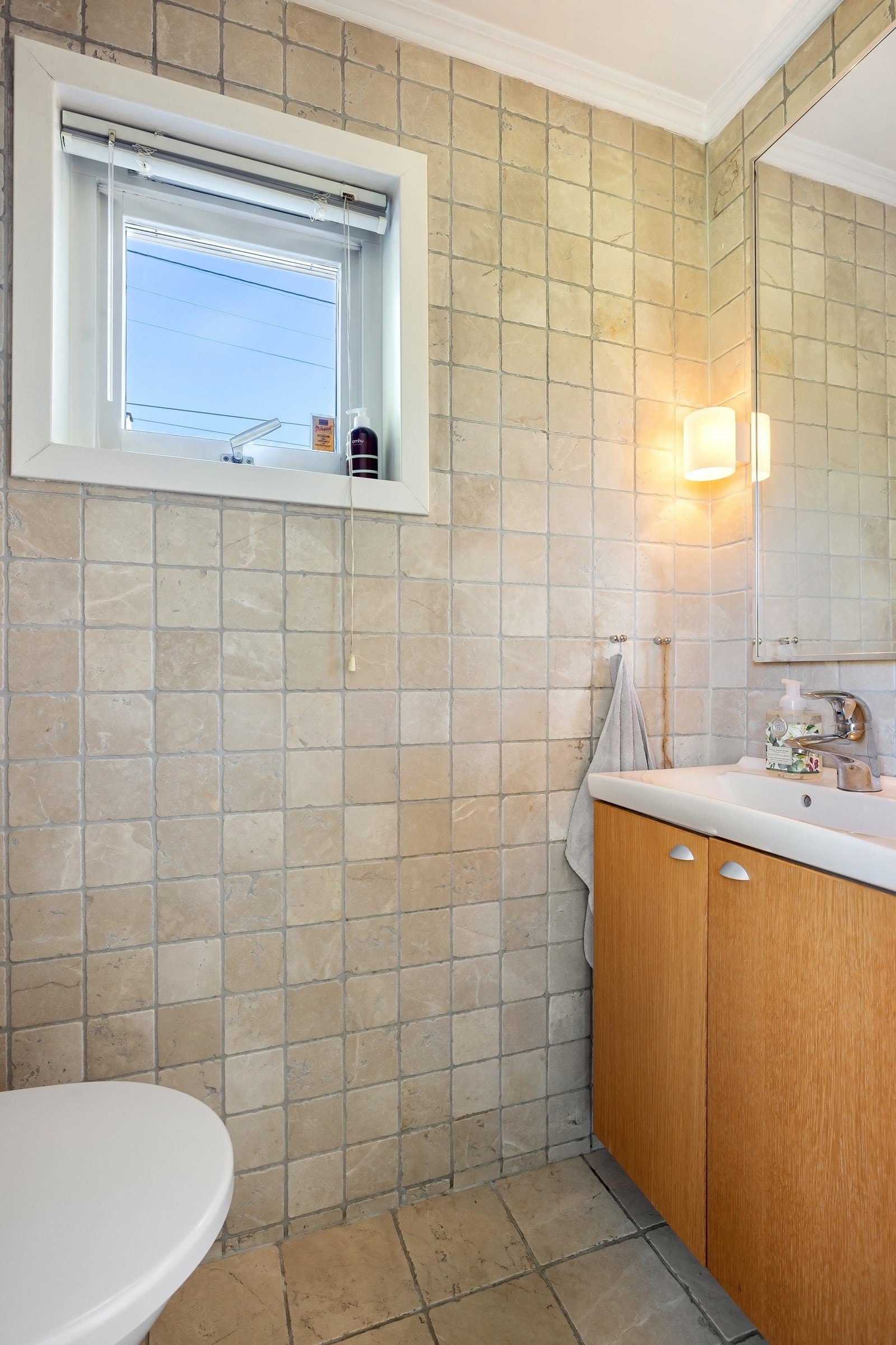 Gjestetoalett har vegghengt toalett, servant med innredning, avtrekk, vindu og belysning. Galleribilde