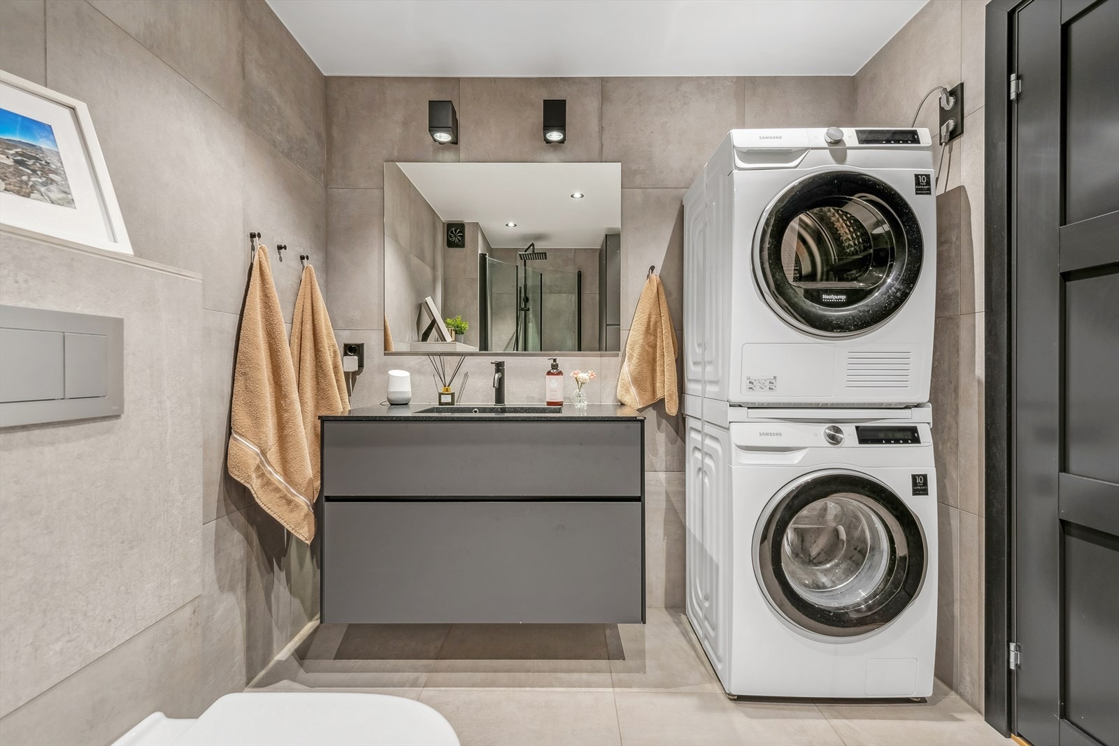 Badet er innredet med servant med skuffeseksjon, vegghengt toalett, dusjhjørne med regnfalldusj og opplegg for vaskemaskin. Mekanisk avtrekk. Galleribilde