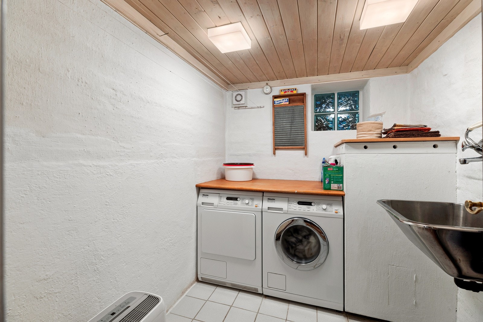 Vaskerommet har flislagt gulv med varme. Det er plass til vaskemaskin og tørketrommel, med benkeplate over. Videre er det en utslagskum i rustfritt stål. Galleribilde