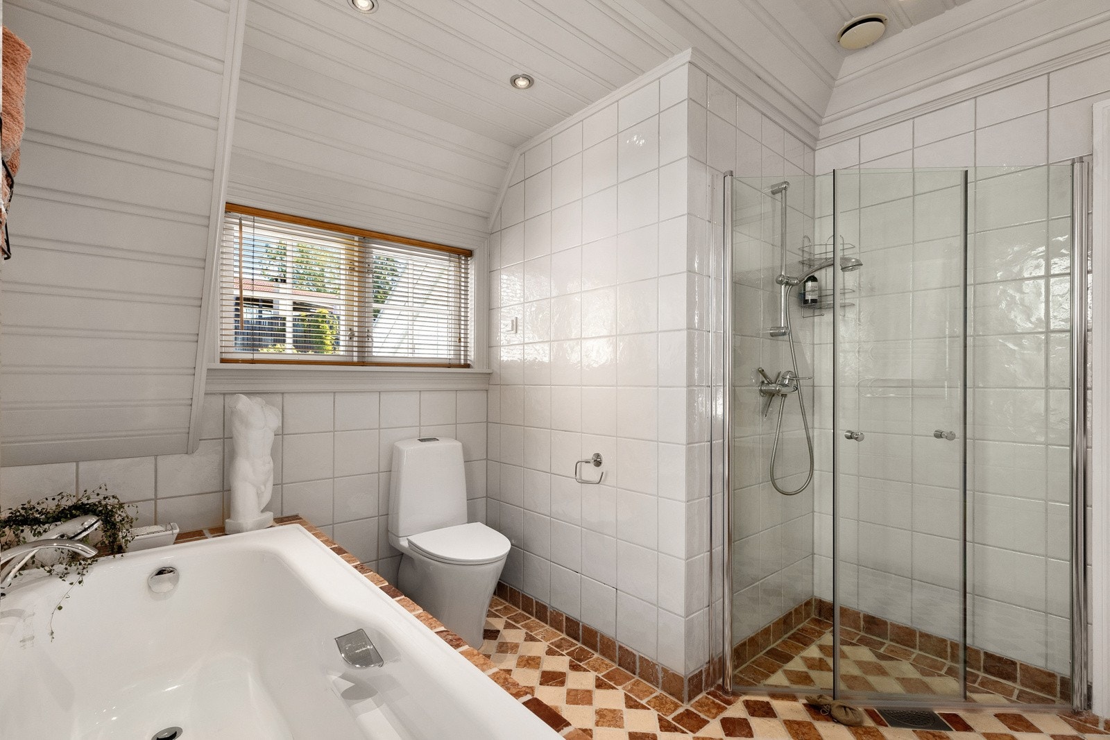 På badet er det både dusj med glassdører og innfliset badekar. Galleribilde