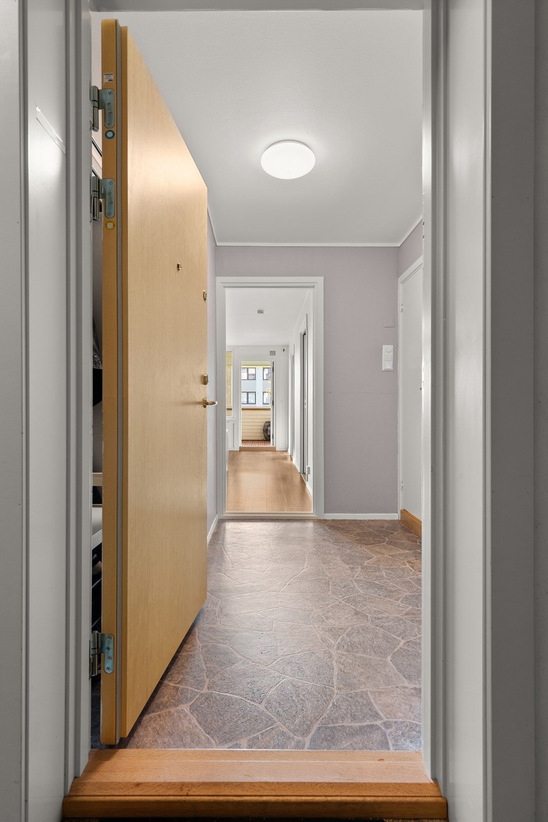 Leiligheten sett fra felles gang. Hele 10 meter fra verandavegg til dør. Galleribilde