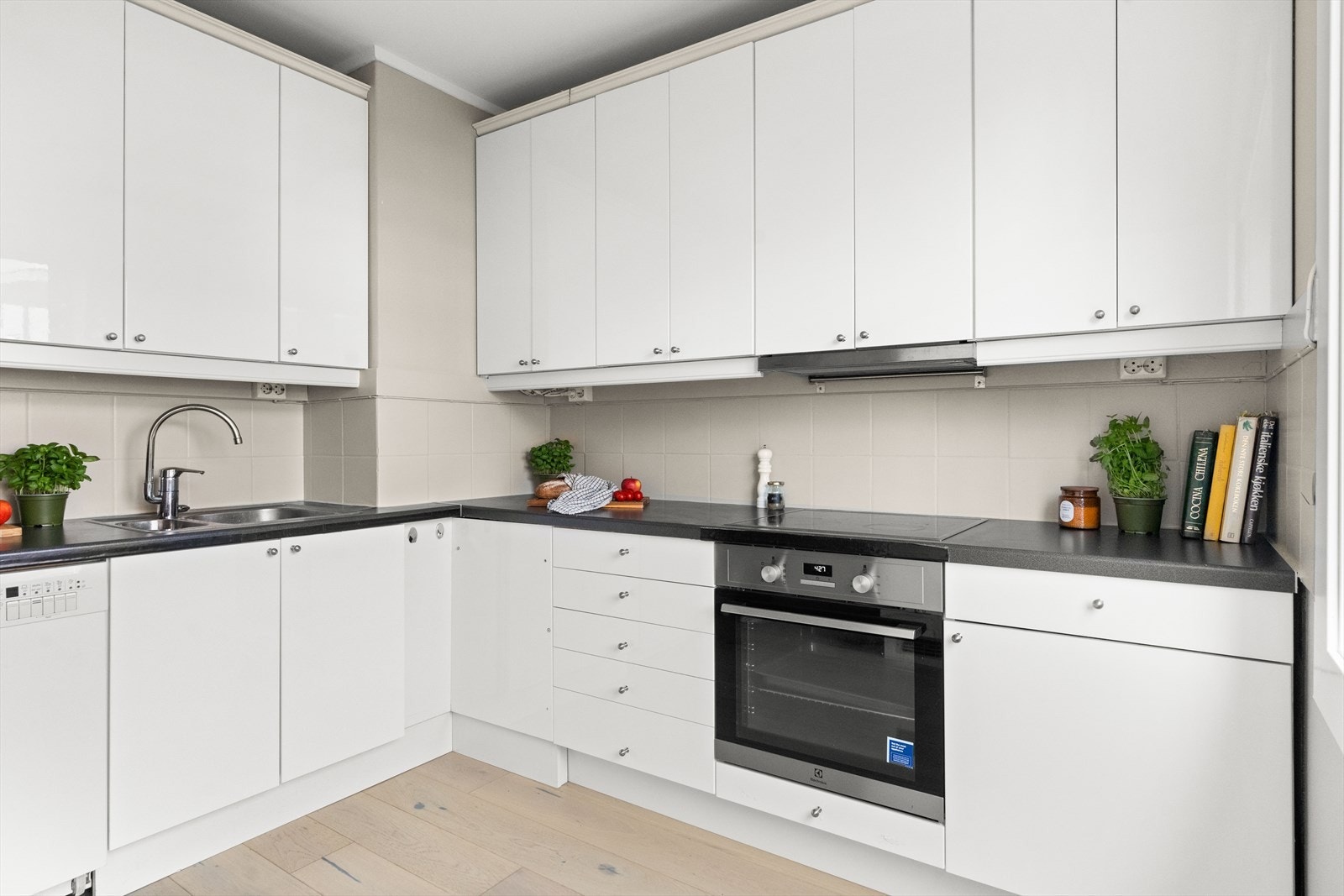 Kjøkkenet har glatte fronter, laminat benkeplate med nedfelt vask- og skyllekum, samt fliser og belysning over benkeplaten. Galleribilde