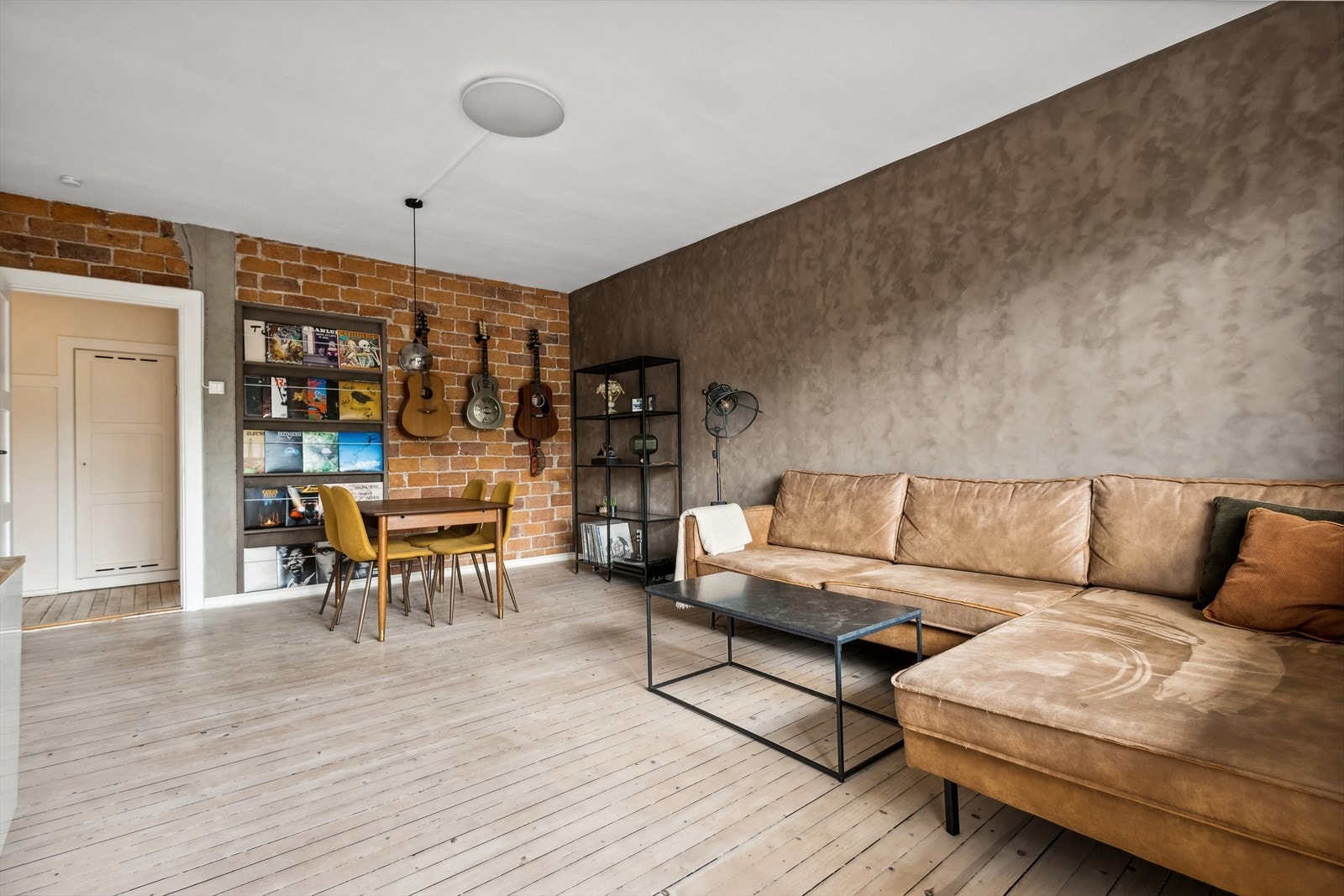 Stuen har originale tregulv og teglsteinsvegg Galleribilde