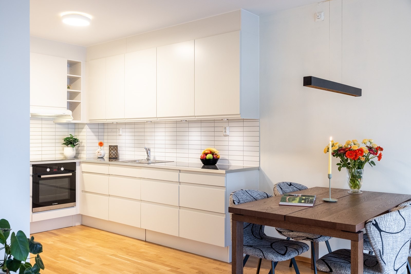 Innbydende og stilrent kjøkken med kjøkkeninnredningen består av hvite, glatte fronter og benkeplate av laminat med nedfelt vaskekum. Galleribilde
