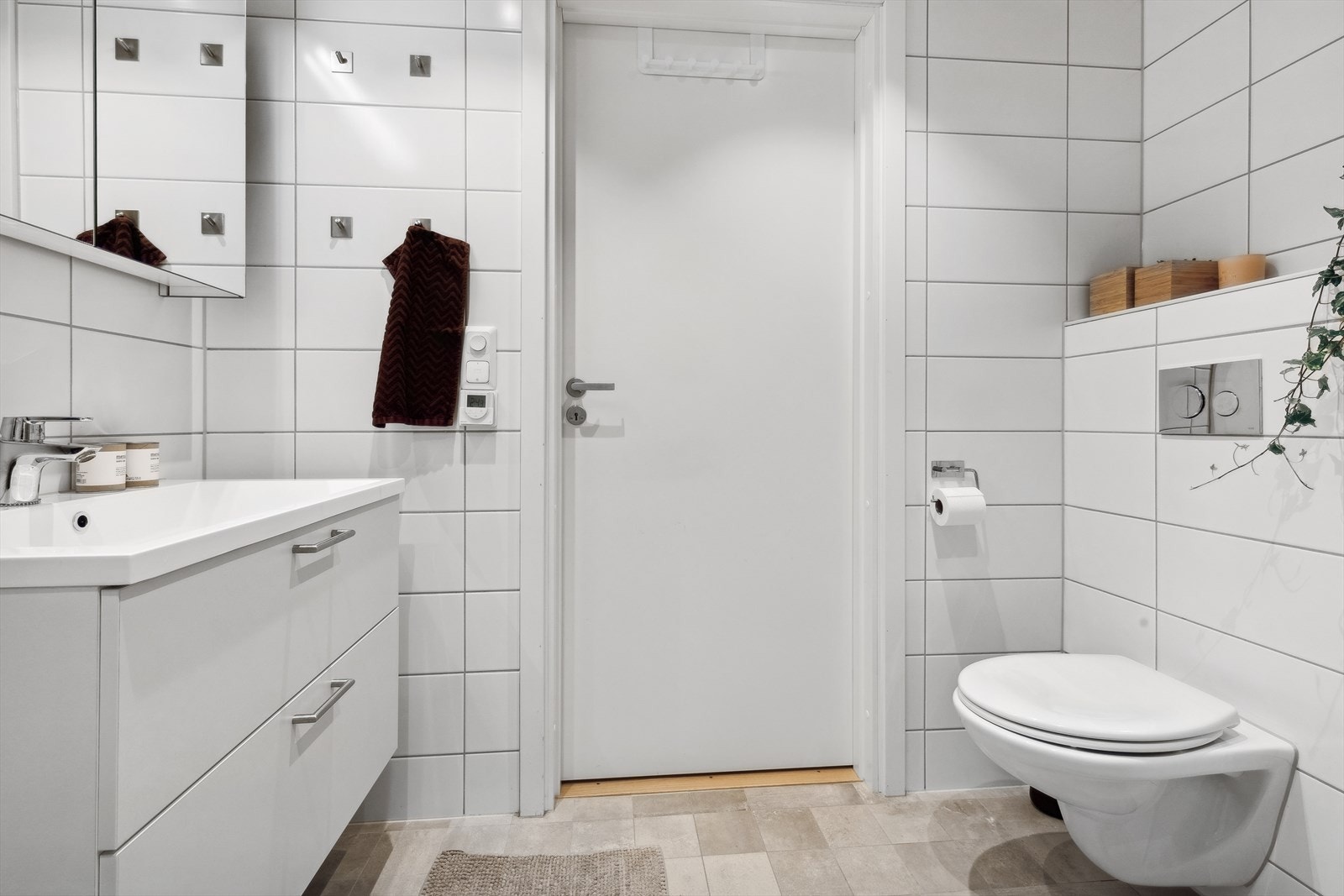 Bad/wc består av vegghengt wc, servant m/underskap, overskap m/speilfronter og overlys, inn-/utadslående dusjdører og opplegg for vaskemaskin. Galleribilde