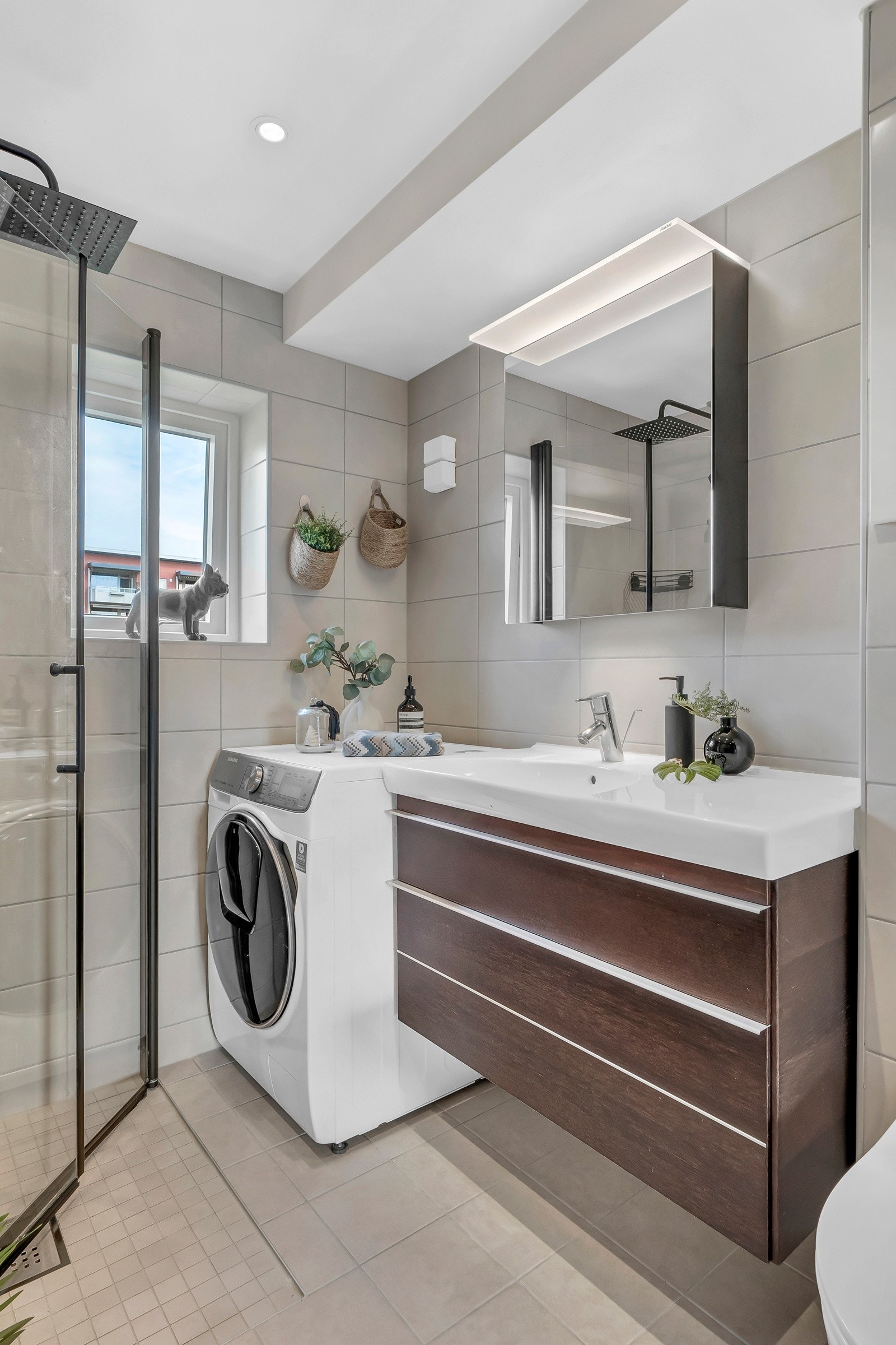 Badet har gode lagringsmuligheter for toalettartikler i speilskap med belysning og servantskap med heldekkende servant. Galleribilde