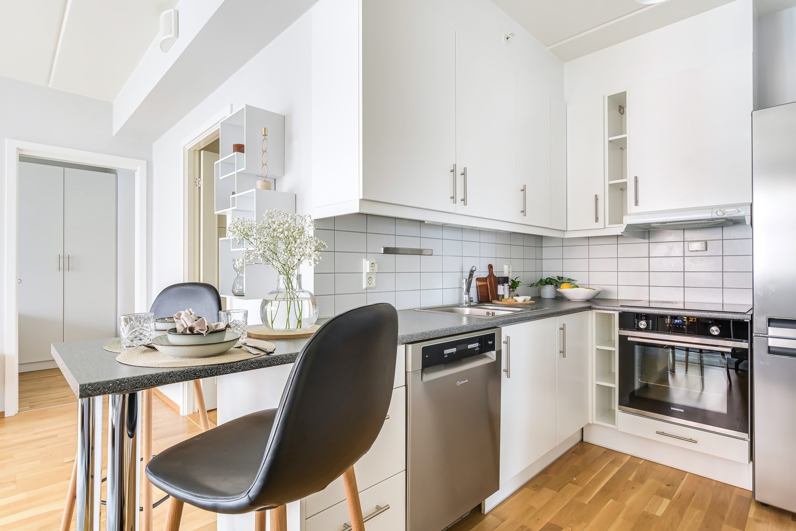 Kjøkkenet har slette fronter og laminat benkeplate med fliser på bakvegg. Galleribilde