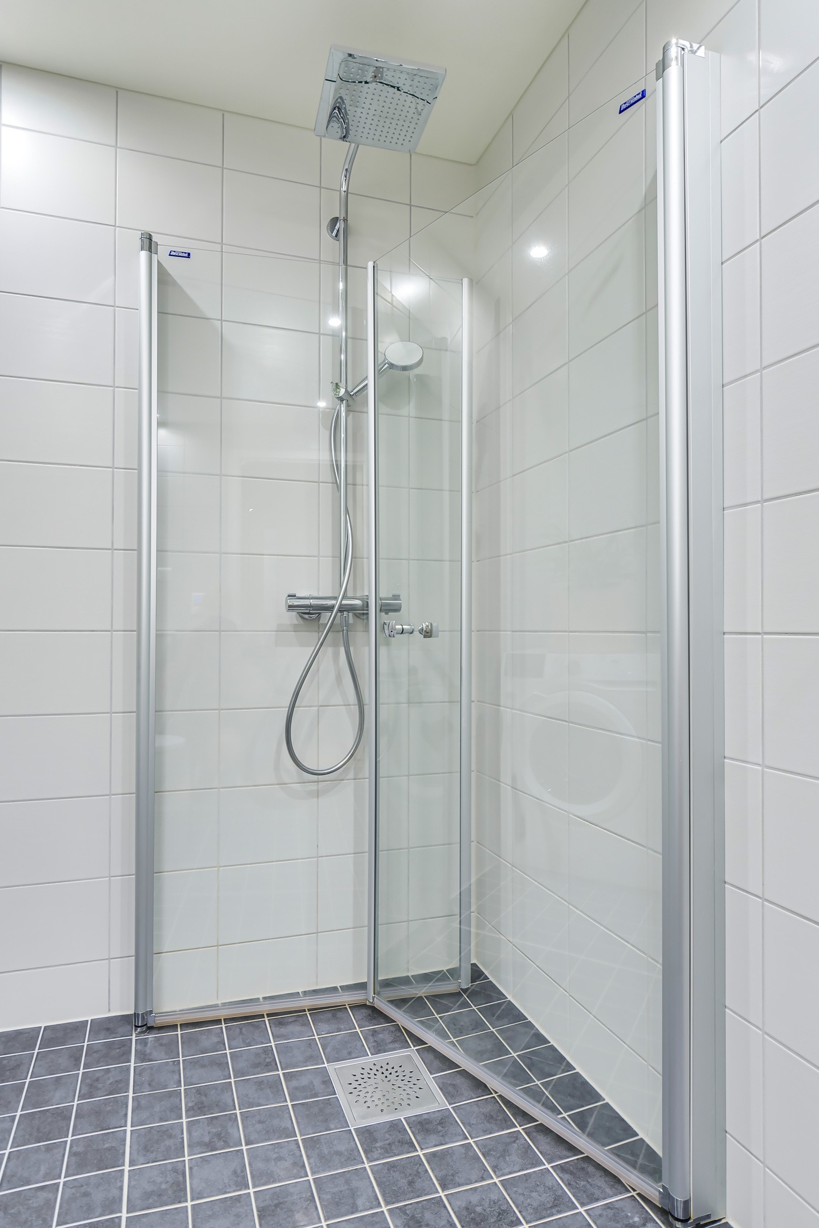 Badet har eget dusjhjørne med praktisk og moderne regnfallsdusj og innfellbare dusjdører. Galleribilde