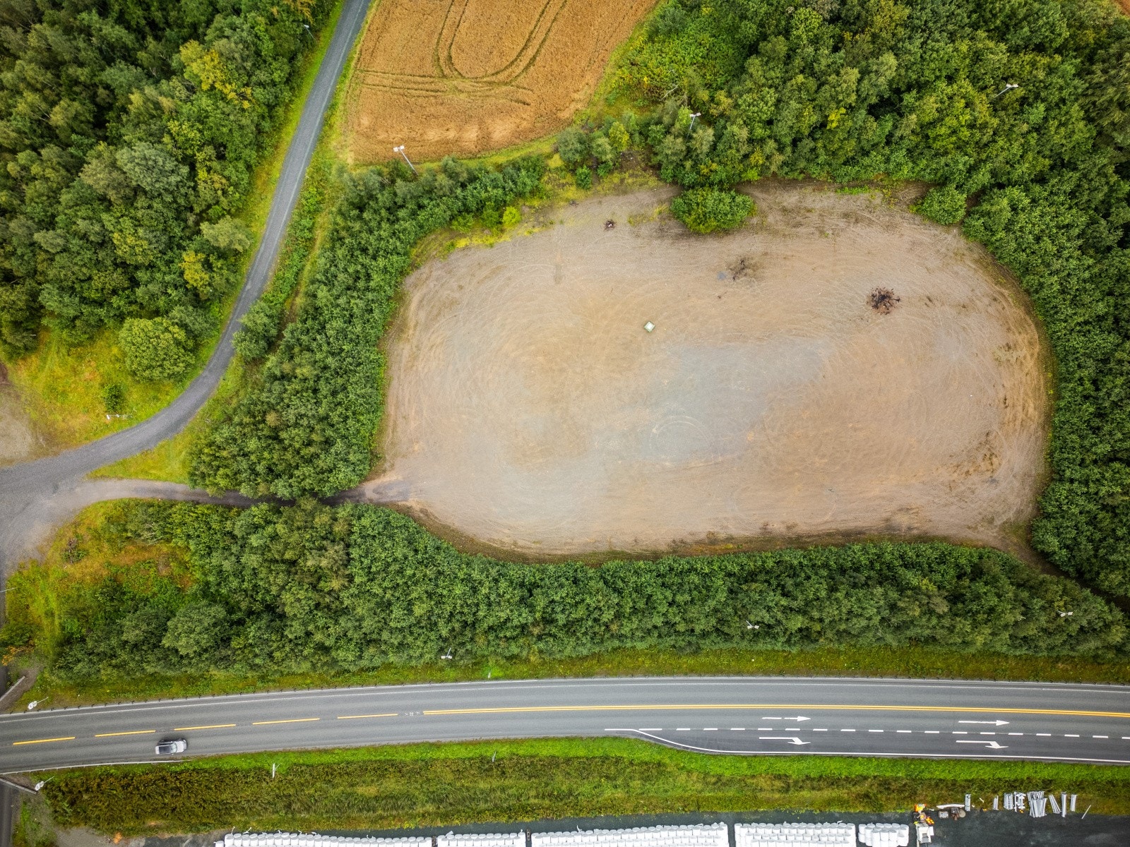 Foruten de 4 500 kvm med gruslagt dekke består tomten av bevokst kratt og lauvskog. Galleribilde