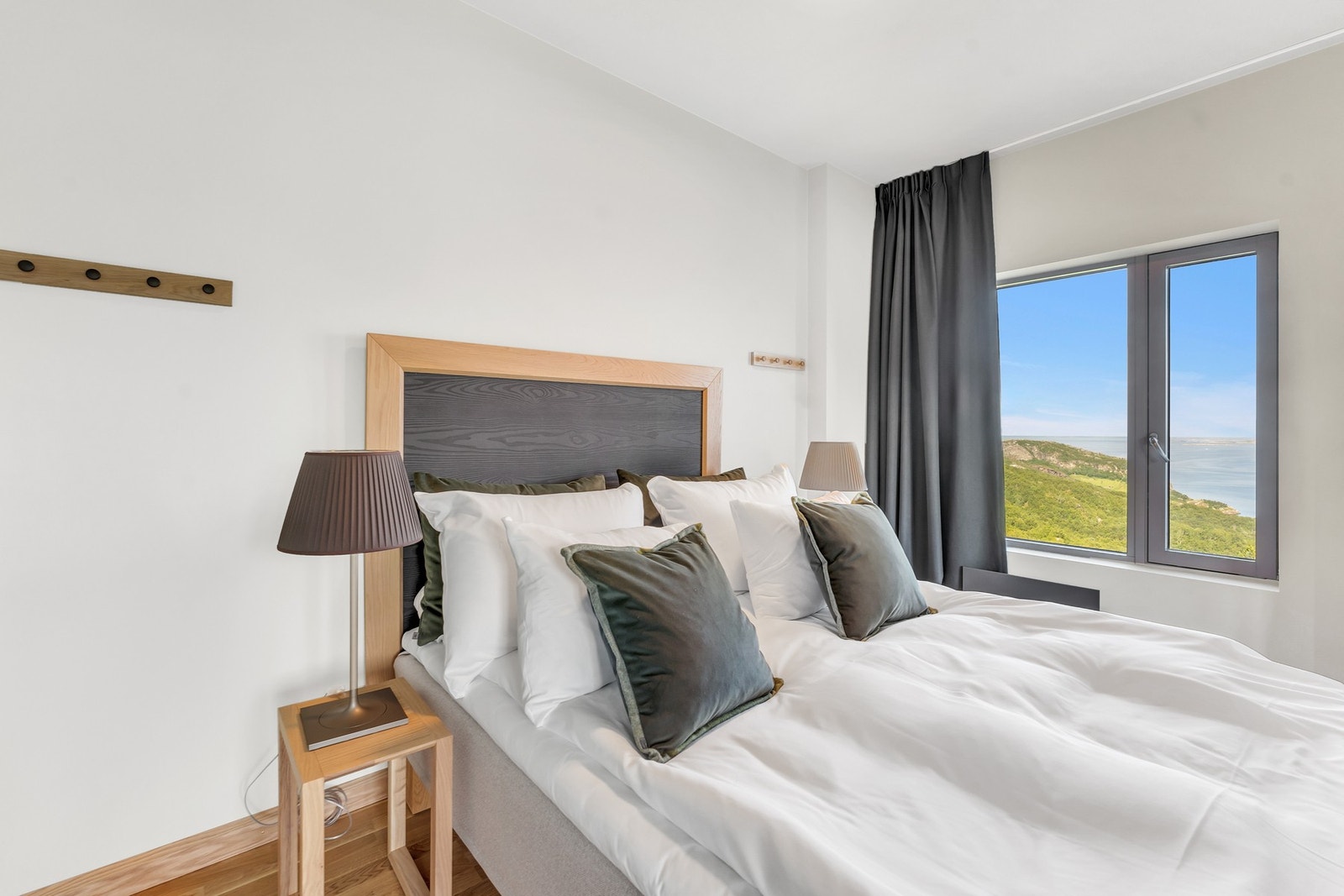 Hotelleilighet - Innbydende soverom med flott utsikt. Komfortabel seng med tilhørende nattbord og moderne belysning. Galleribilde