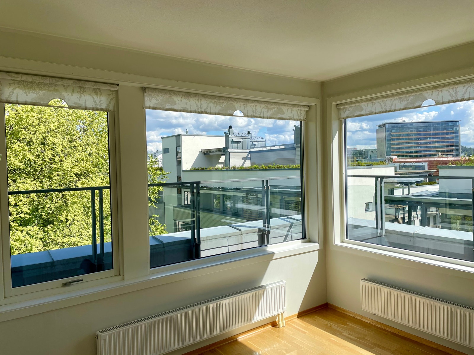 Utsikt mot parkanlegg og regjeringskvartal fra stue og balkong. Galleribilde