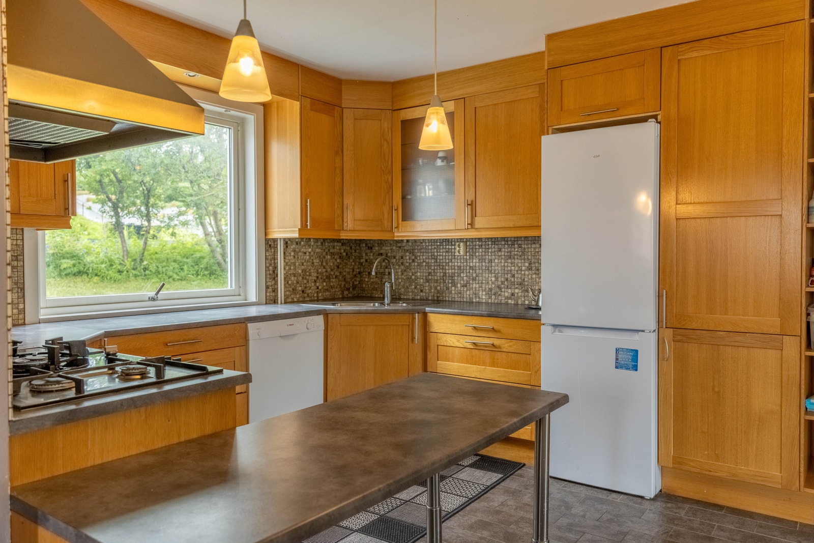 Kjøkkeninnredningen består av skap med profilerte fronter og benkeplate i laminat. Galleribilde