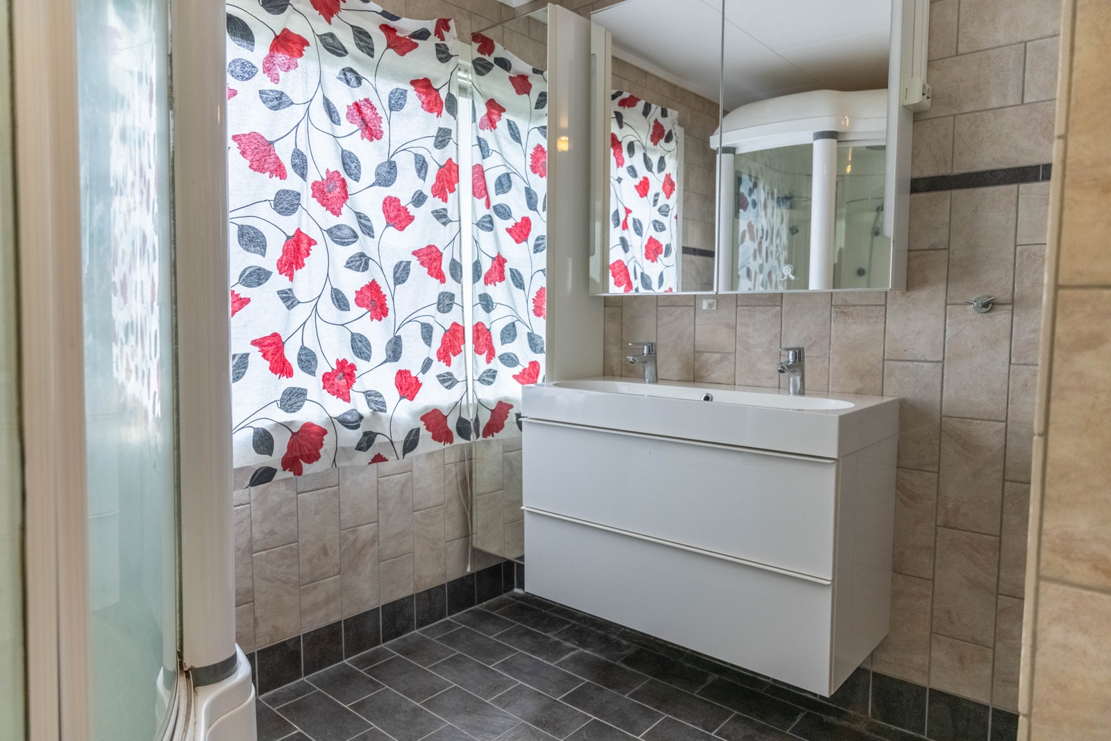 Baderomsinnredningen består av servant med over- og underskap, dusjkabinett, vegghengt toalett og opplegg til vaskemaskin. Galleribilde