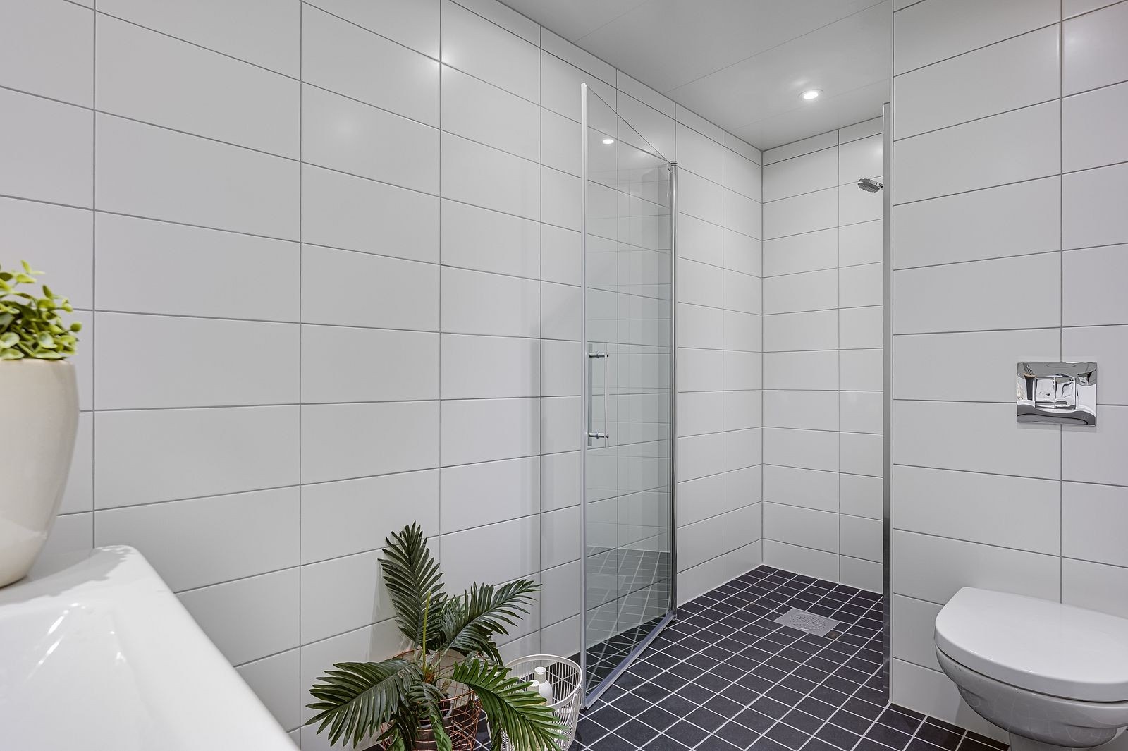 Flott bad med dusjnisje, vegghengt WC og opplegg for vaskemaskin og tørketrommel Galleribilde