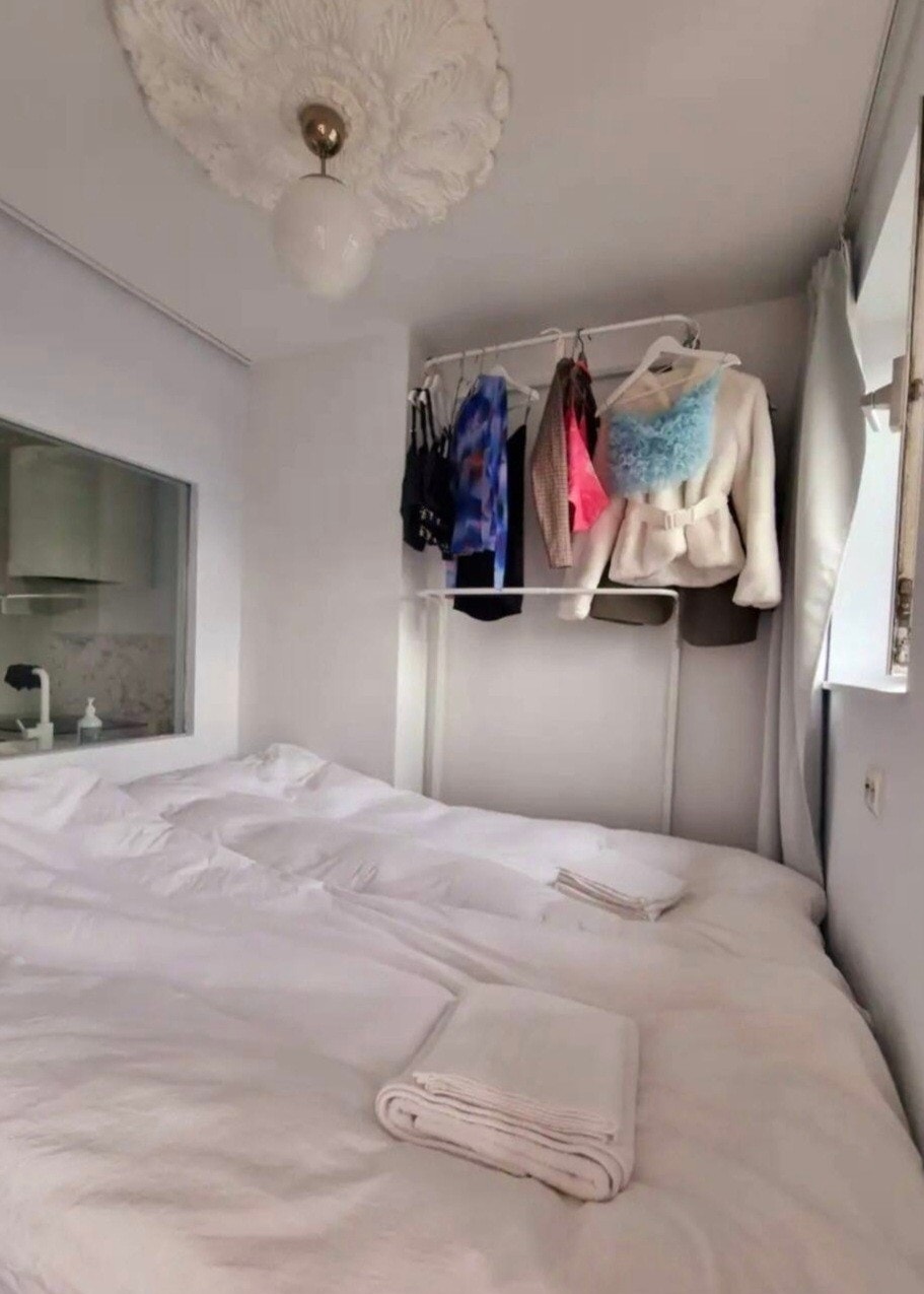 Soverom. Dobbeltseng og oppheng til klær følger med. Leietaker må ha egen overmadrass. Vinduet mellom soverom og kjøkken er kun for å slippe inn lys på kjøkken. 3 mørklagte gardiner (følger med). Seng 150×200 Galleribilde