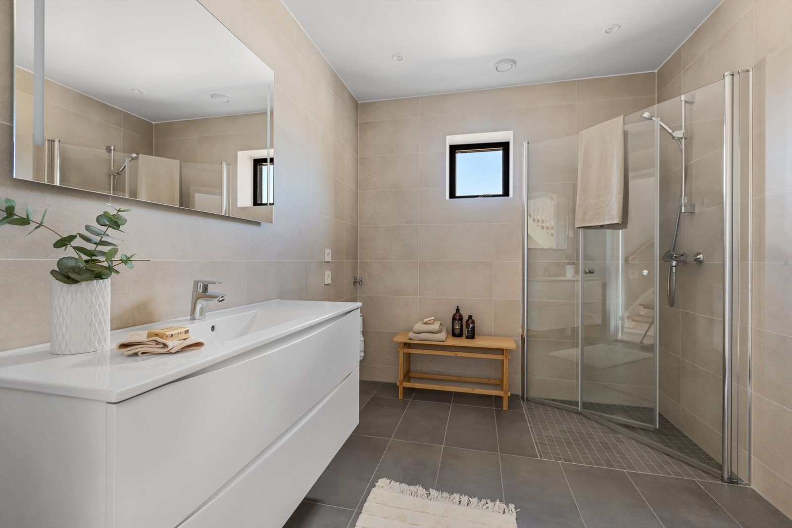 Boligen har et stort flislagt baderom med varmekabler i gulv og downlights i himling. Galleribilde