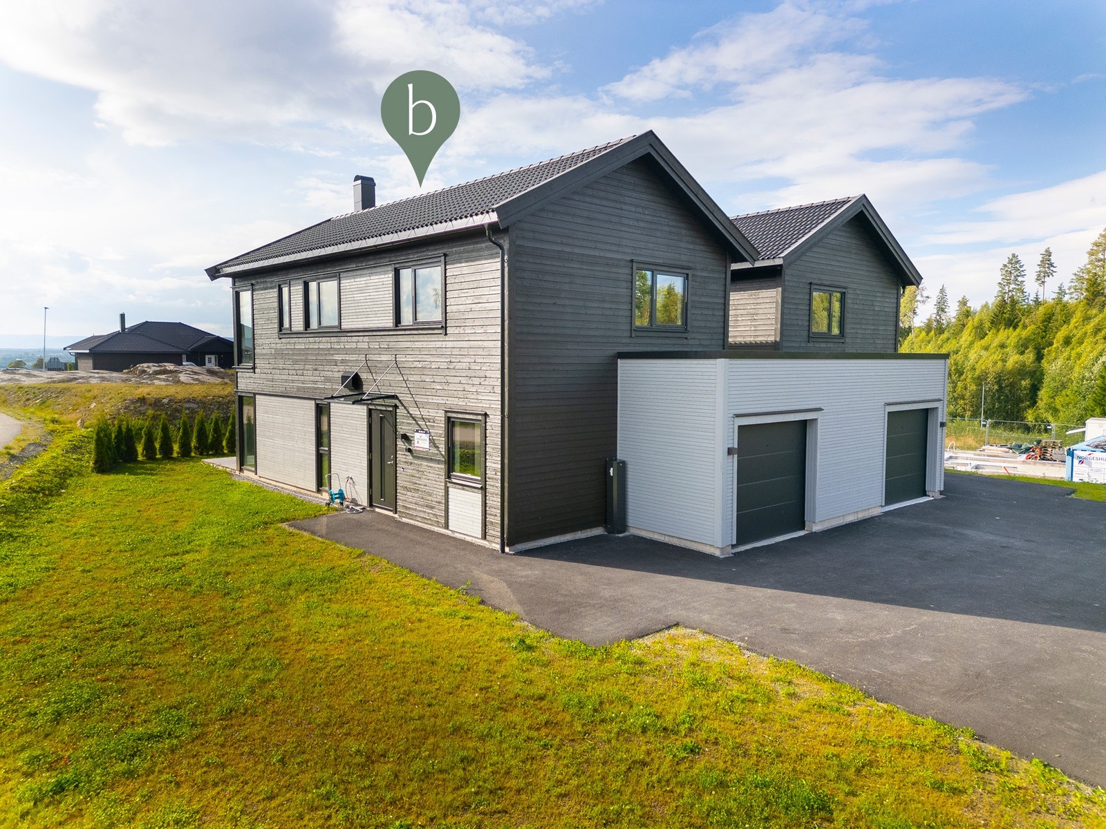 Boligen har garasje med bod, de to boligene deler en stor felles asfaltert gårdsplass. Foto er av samme type bolig på annen tomt (Trollkoken 2). Avvik kan forekomme. Galleribilde