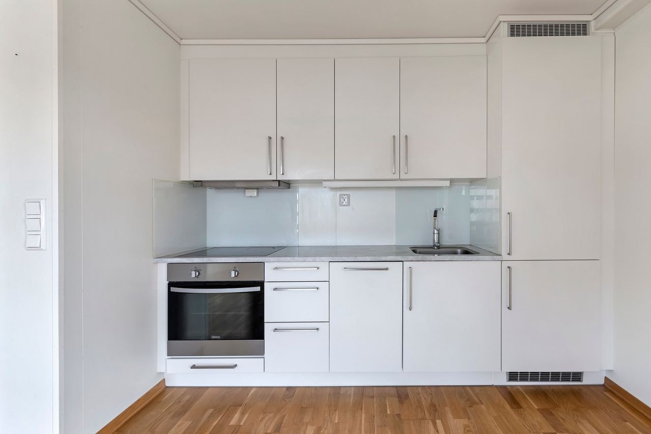 Kjøkkeninnredning har glatt fronter med laminert benkeplate integrer stekeovn, koketopp, oppvaskemakin og frys/kjøleskap Galleribilde