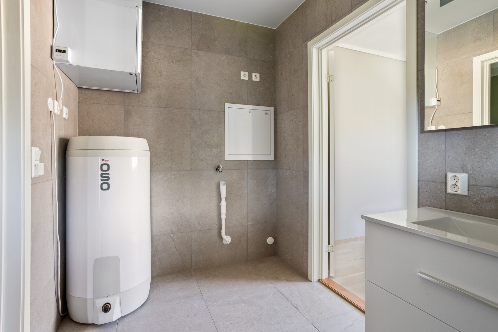 Det er plass til oppvaskmaskin og tørketrommel på badet. Galleribilde