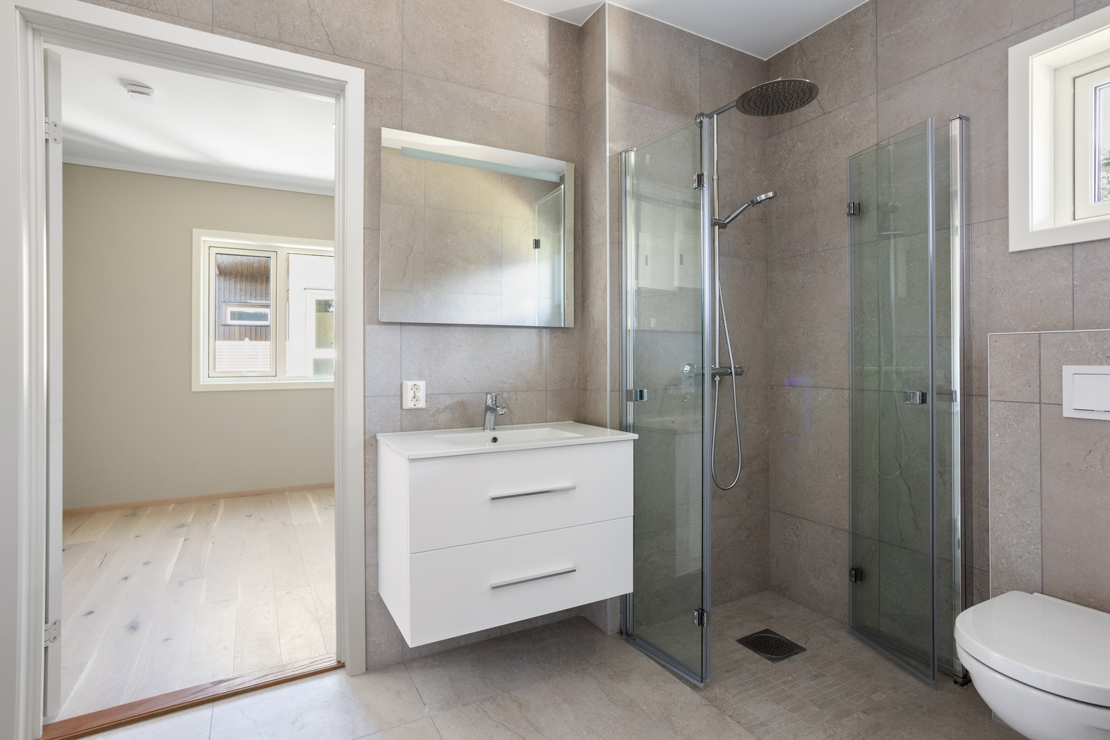 Badet har takdusj, lysspeil og vegghengt toalett. Galleribilde