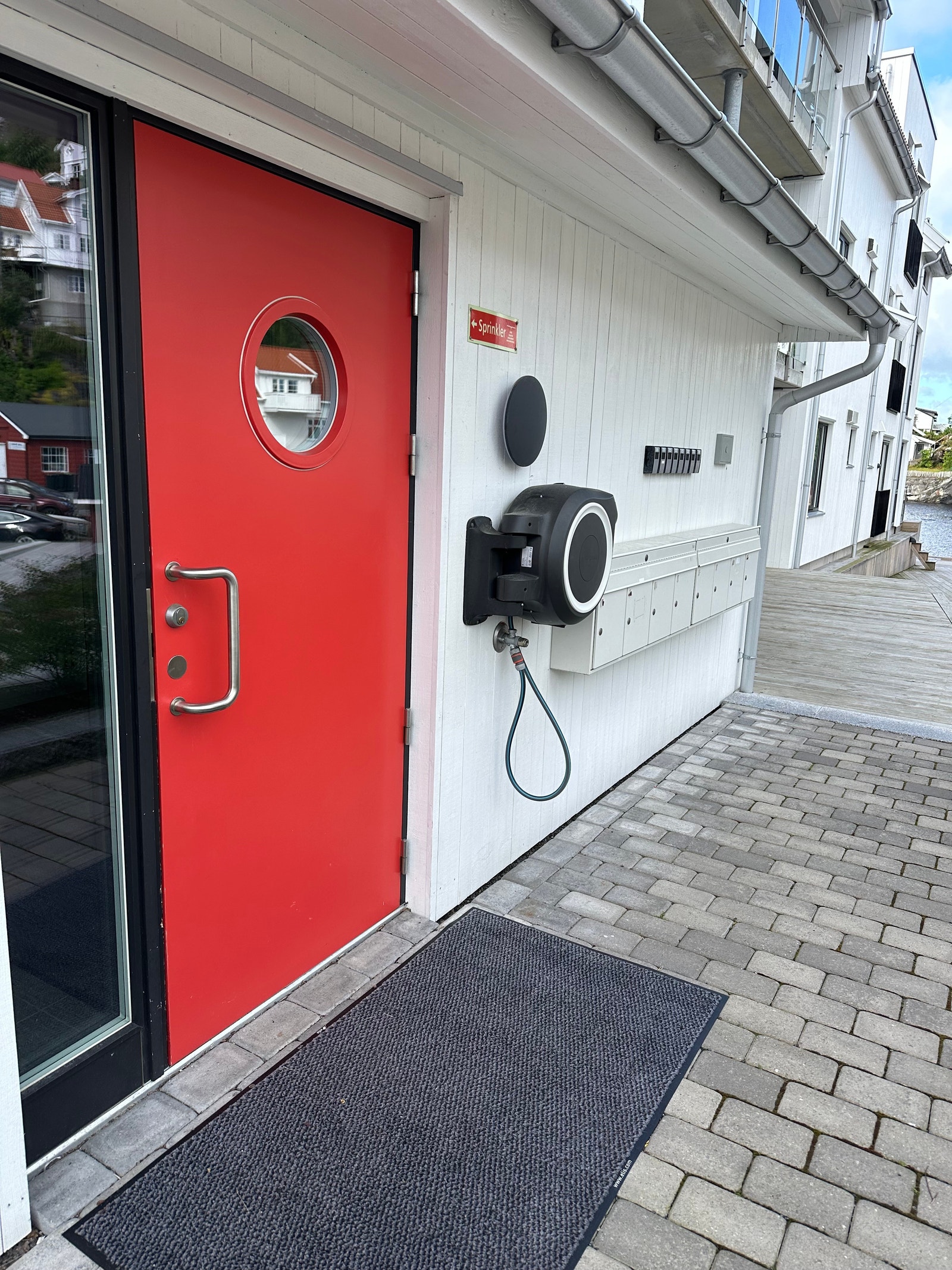 Inngang gjennom rød dør. Heis eller trapp til leiligheten som er i 2. etasje. Galleribilde