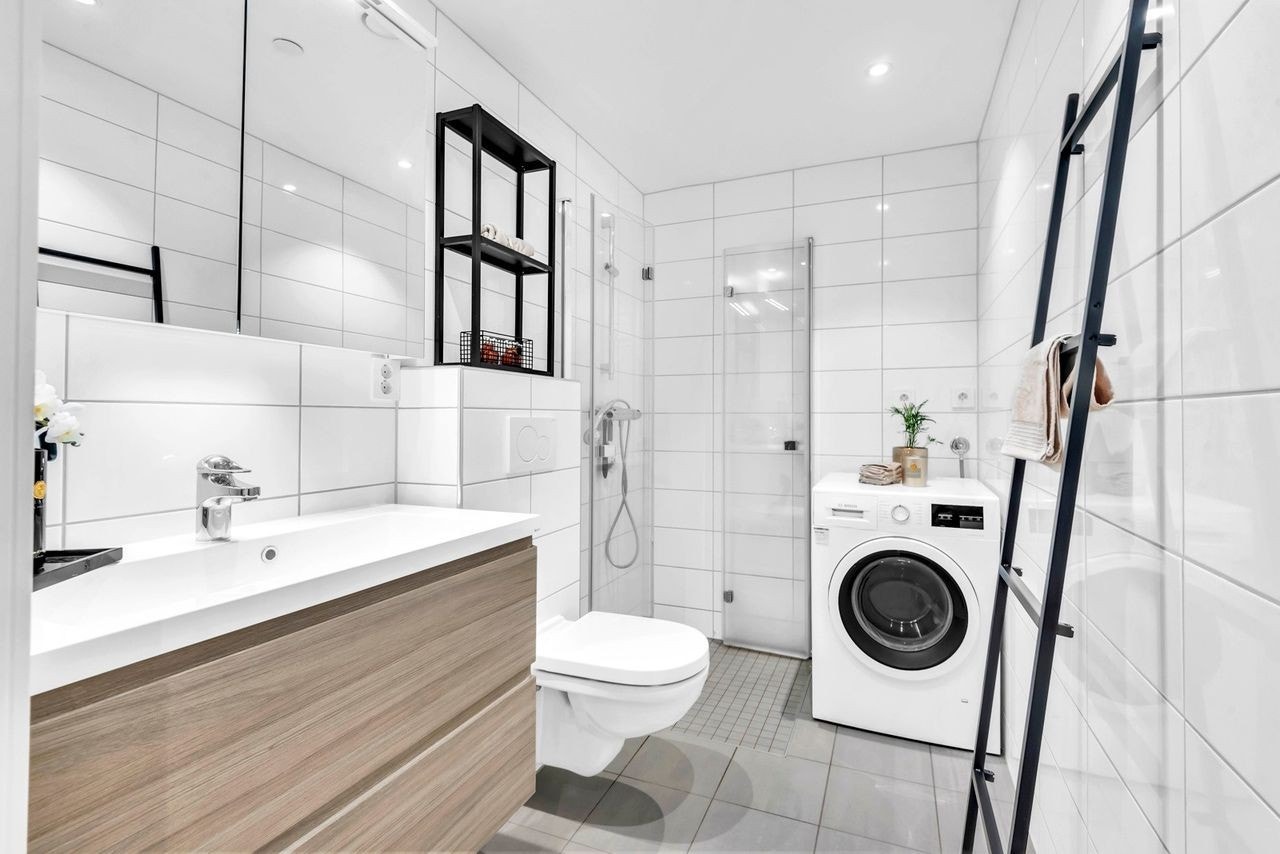 Lekkert flislagt bad med opplegg for vaskemaskin. Galleribilde