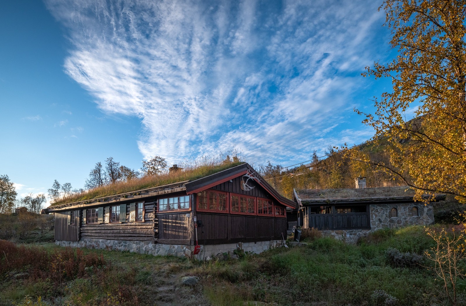 Hytta sett fra parkeringsplassen. El-bil lader er tilgjengelig på hytteveggen. (Den lille hytta til høyre i bildet tilhører eiendommen, men er ikke i bruk som utleieenhet) Galleribilde