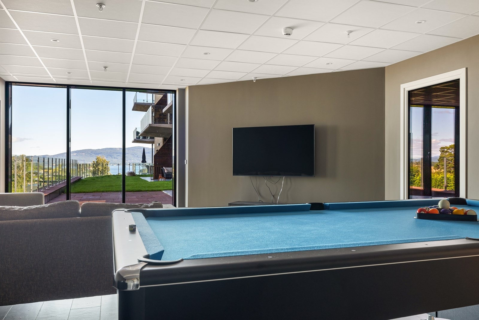 Flott fellesrom med blant annet biljardbord, kjøkkeninnredning, tv og sofagruppe Galleribilde