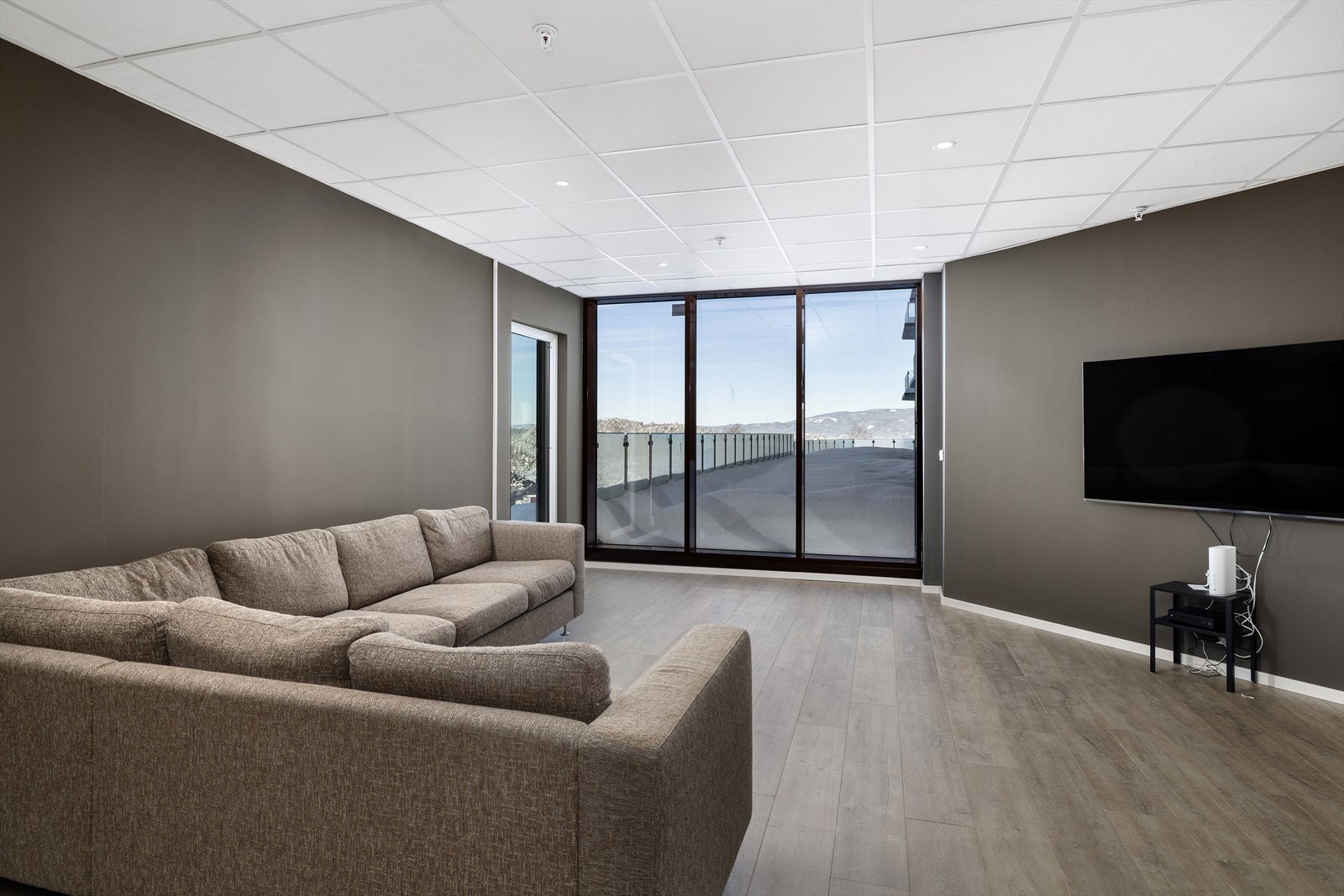 Sameiet har også et stort fellesrom utstyrt med stor sofa, TV og kjøkkeninnredning med vask og oppvaskmaskin Galleribilde