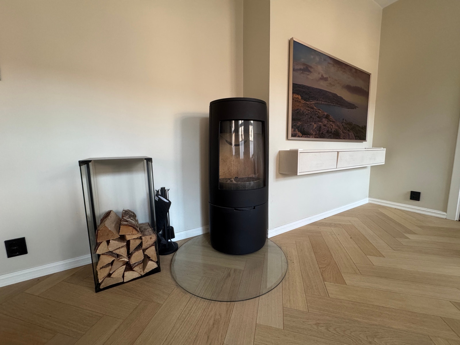Nydelig og moderne peis fra Dovre, som passer fint inn med øvrig interiør, og bidrar med ekstra varme under vinteren. Vedstativ og tilbehør medfølger. Galleribilde