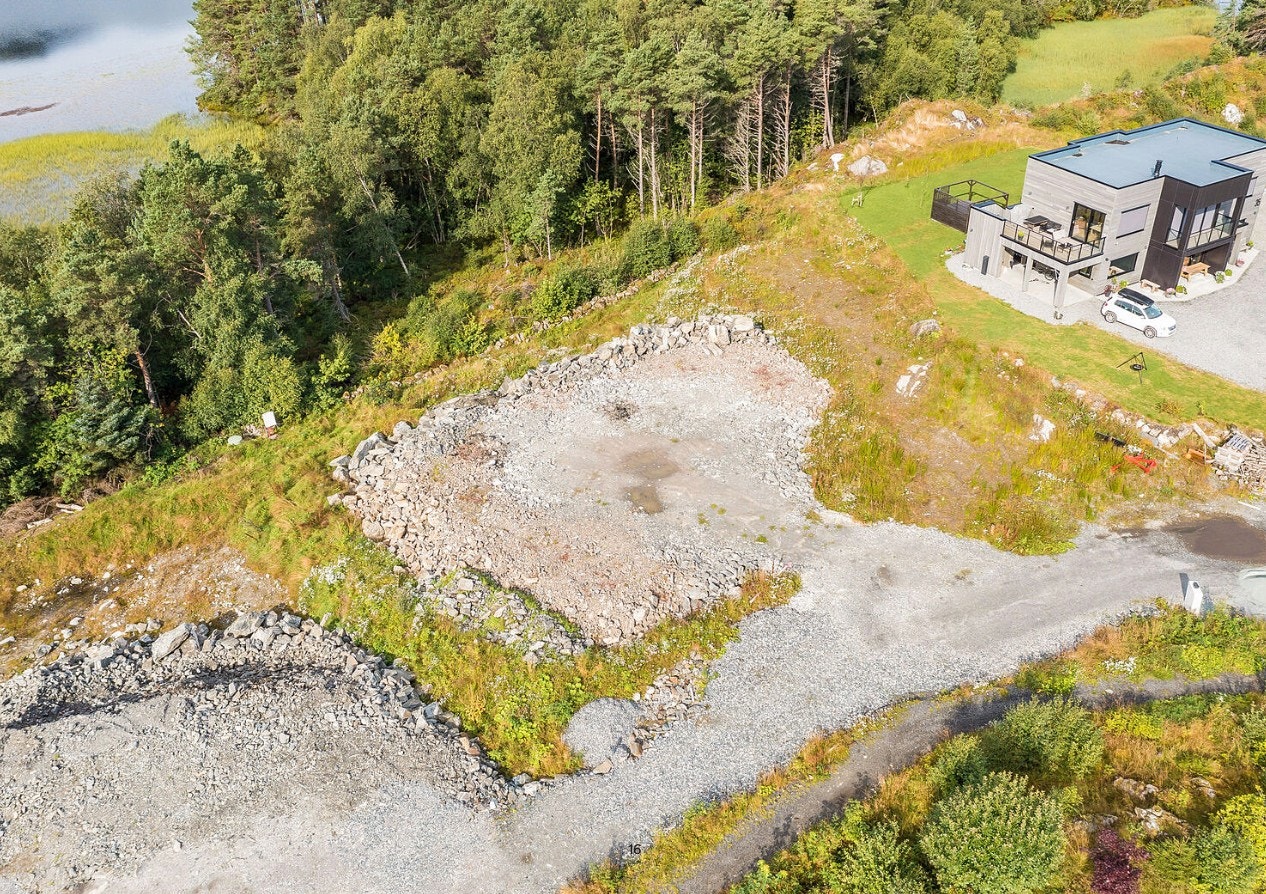 Dronebilde av tomten før felling av skog ned mot Raudåvatnet. Galleribilde