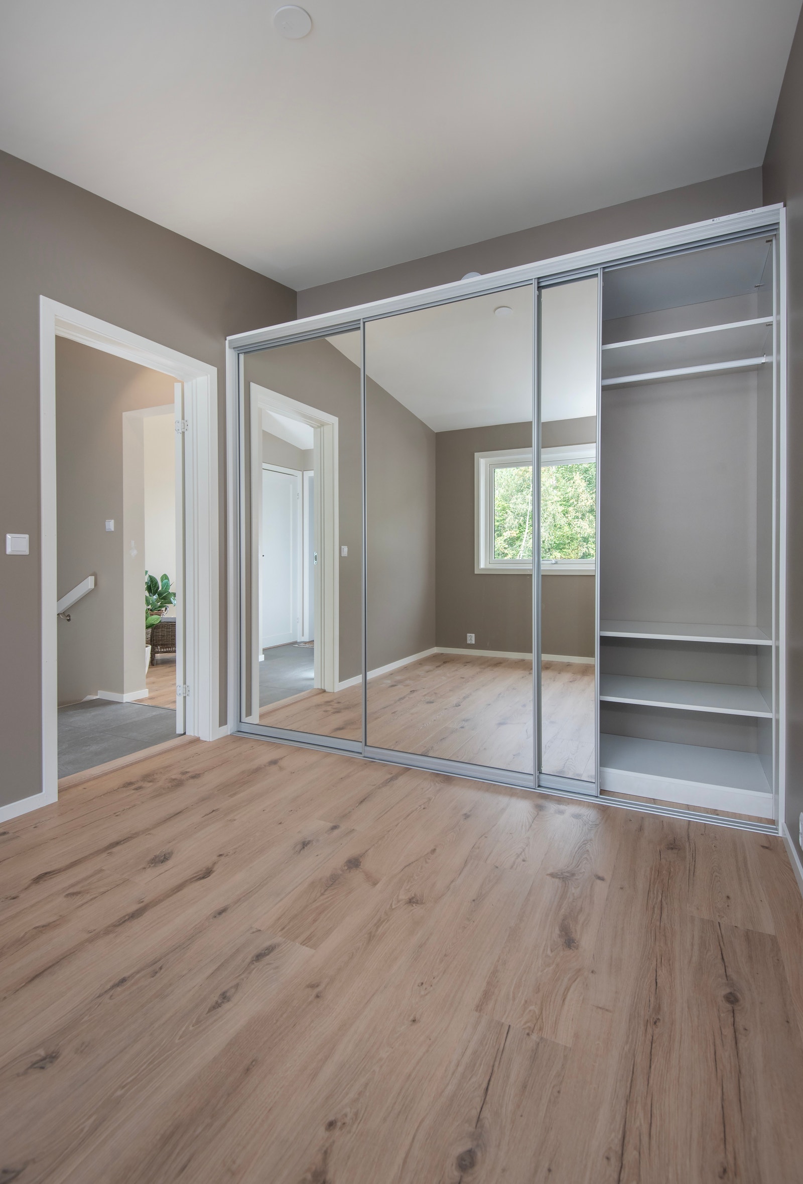 Praktisk skyvedørsgarderobe med dører i speil og innreiing for god plass til oppbevaring Galleribilde