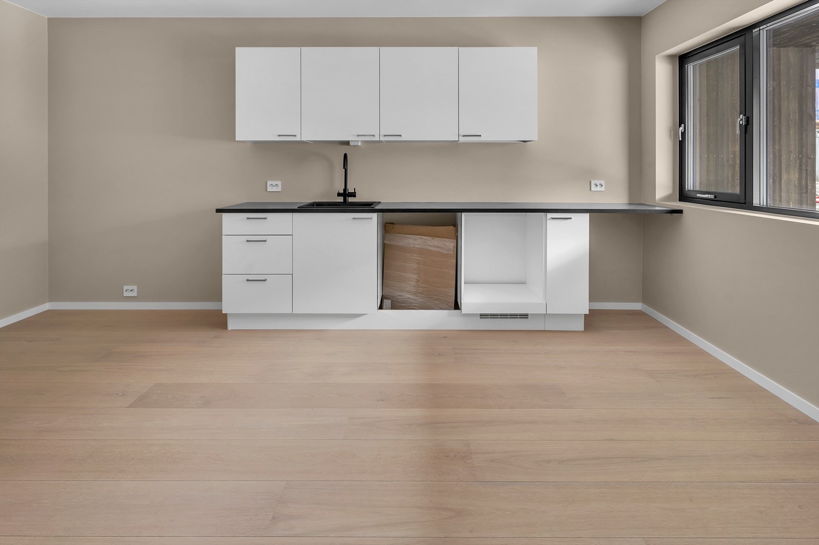 Romslig kjøkken med moderne innredning og store vindusflater som slipper inn rikelig med naturlig lys. Foto fra bolig nr 5. Galleribilde