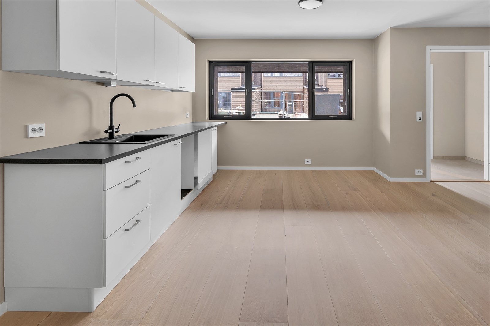 Praktikantdel med kjøkken fra Strai Kjøkken. Moderne sorte detaljer. Oras Saga blandebatteri. Foto fra bolig nr 5. Galleribilde