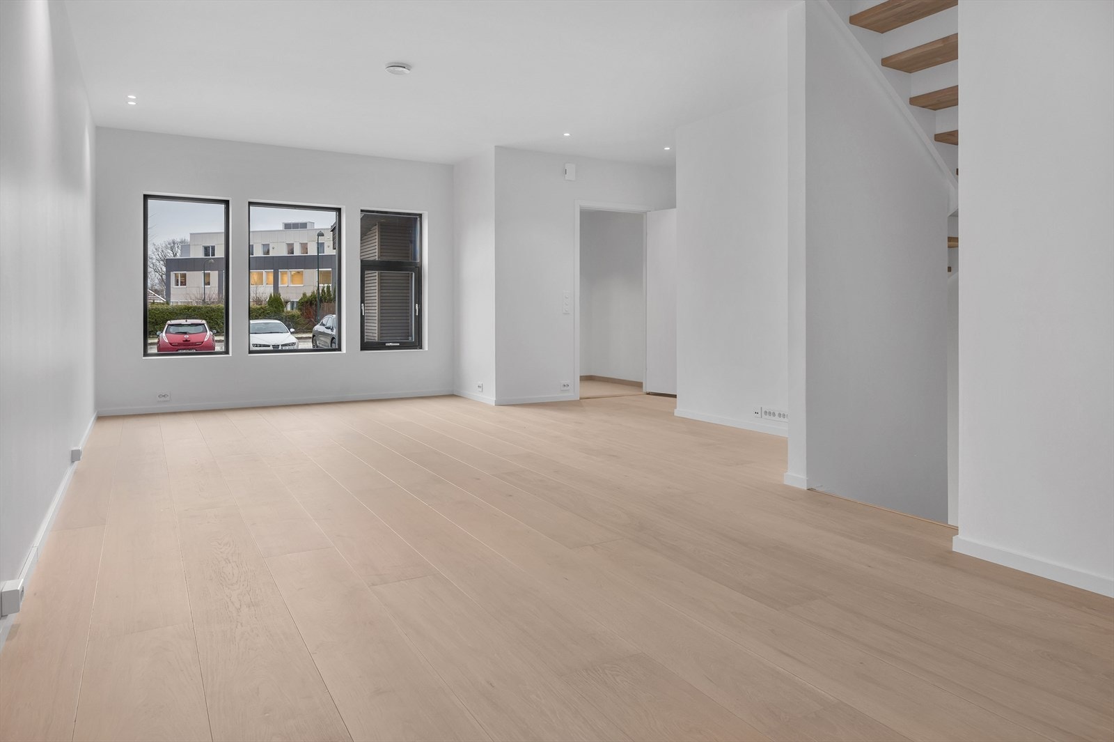 Lys og romslig stue med store vinduer som slipper inn mye naturlig lys. Moderne og stilren planløsning. Perfekt for familier. Foto fra bolig nr 5. Galleribilde