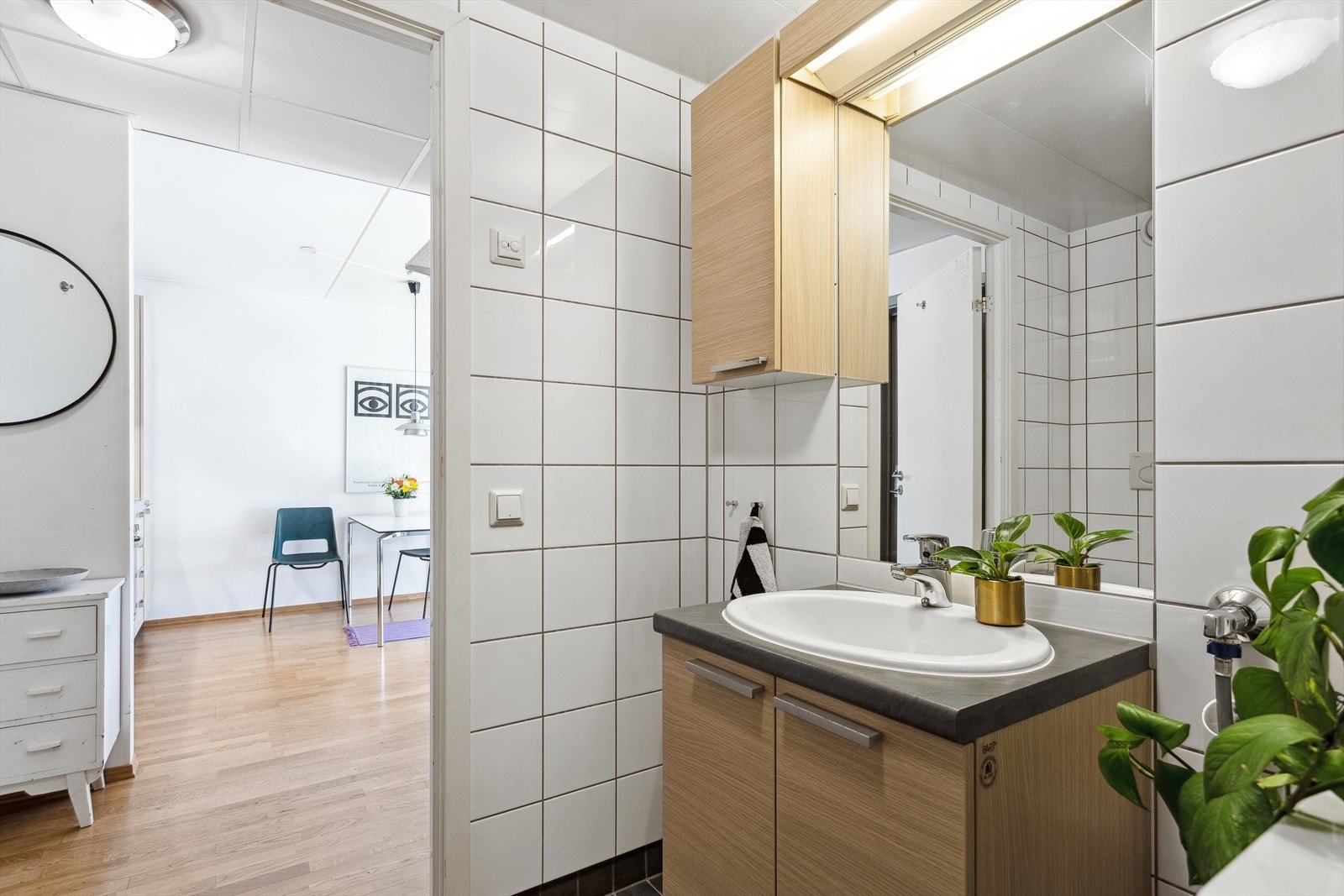 Badet består av vegghengt wc, servant m/underskap, innfliset speil m/overlys, veggskap, inn-/utadslående dusjdører og opplegg for vaskemaskin. Galleribilde