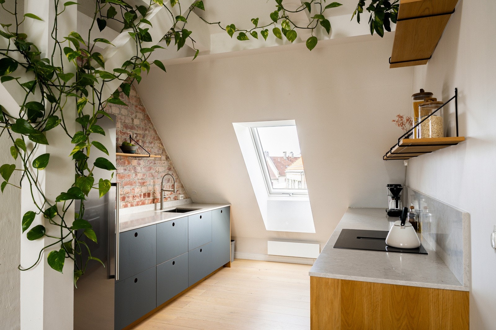 Det flotte kjøkkenet fra 2021 med fronter av linoleum, benkeplate av kvartzkompositt og detaljer av eikefiner som sammen med den eksisterende teglveggen løfter opplevelsen. Galleribilde